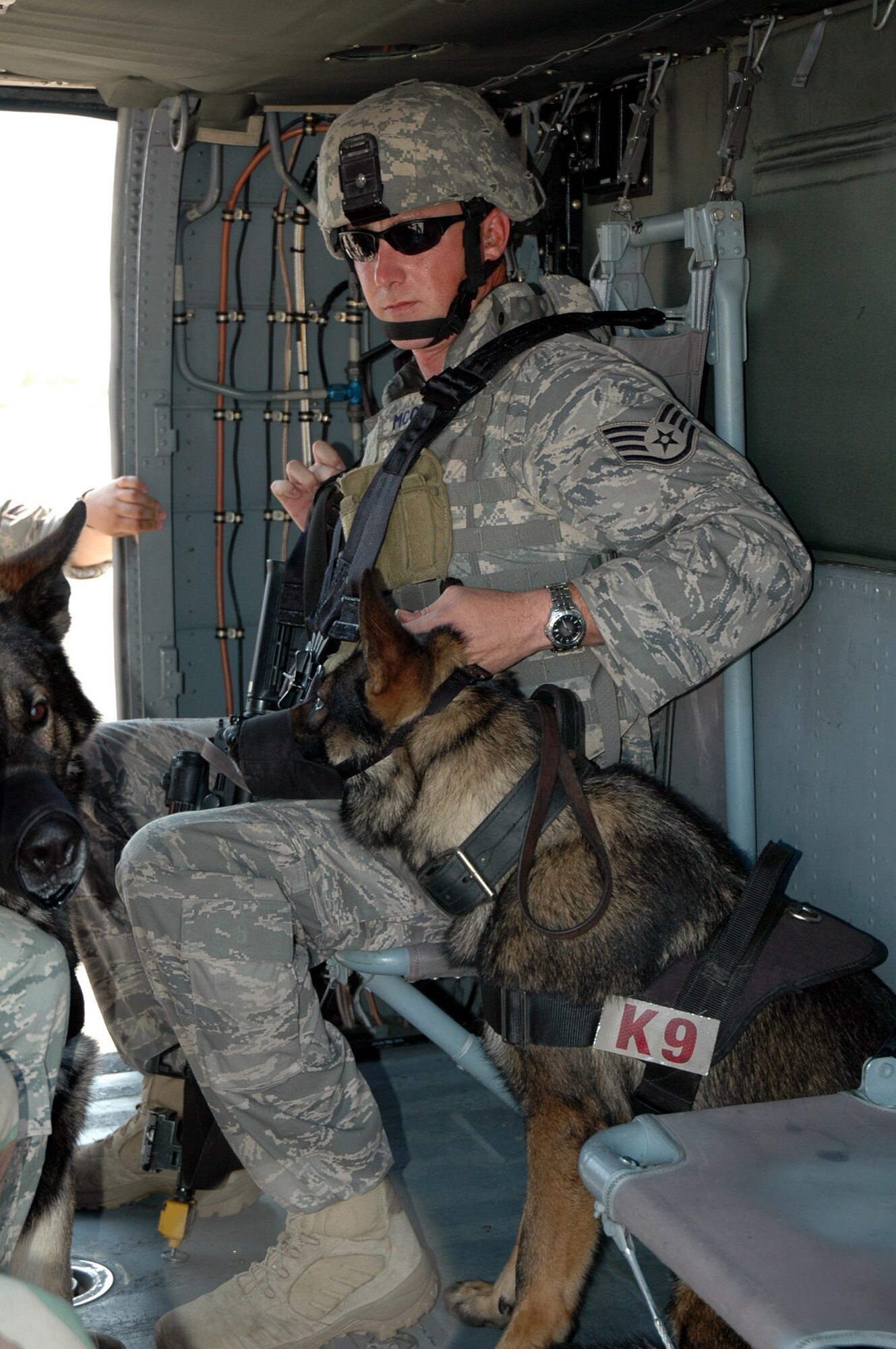 Staff Sgt. David McClain and his military working dog Bak, from the 43rd Security Forces Squadron at Pope Air Force Base, N.C., and both students in the U.S. Air Force Expeditionary Center's Phoenix Warrior Training Course canine track, learn about loading and unloading aboard a Blackhawk helicopter July 8, 2008, on Fort Dix, N.J.  The instruction was part of training for the course where military working dog teams learn to fly aboard helicopters.  Phoenix Warrior is taught by the USAF EC's Expeditionary Operations School and 421st Combat Training Squadron preparing security forces for upcoming deployments.  (U.S. Air Force Photo/Staff Sgt. Paul R. Evans)
