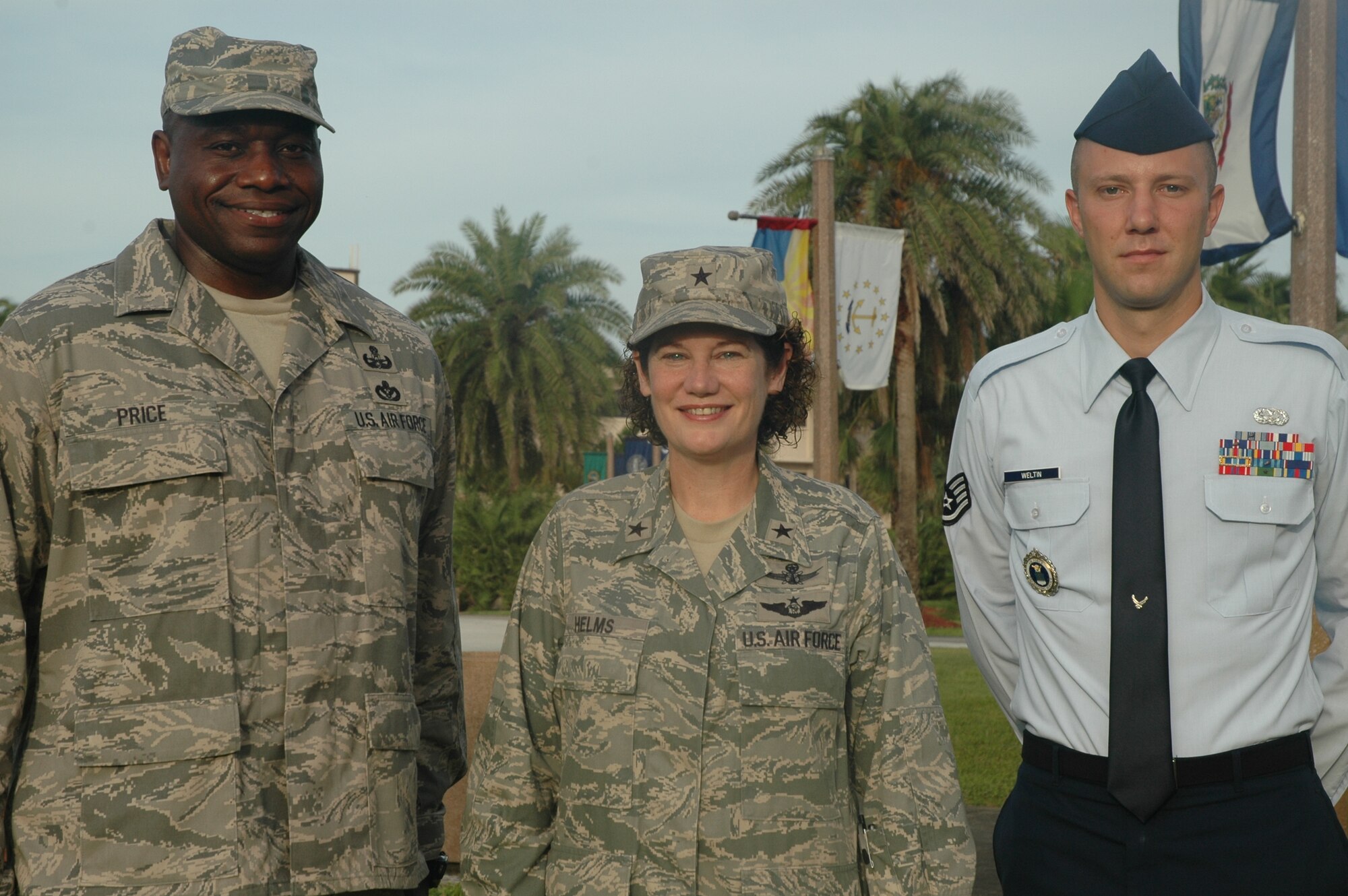 Two of the 12 Outstanding Airmen of the Year, Master Sgt. George Price (left) of the 45th Civil Engineer Squadron and Staff Sgt. James Weltin of the 333rd Recruiting Squadron, share a photo with 45th Space Wing Commander Brig. Gen. Susan Helms July 10. (U.S. Air Force photo by Chris Calkins)