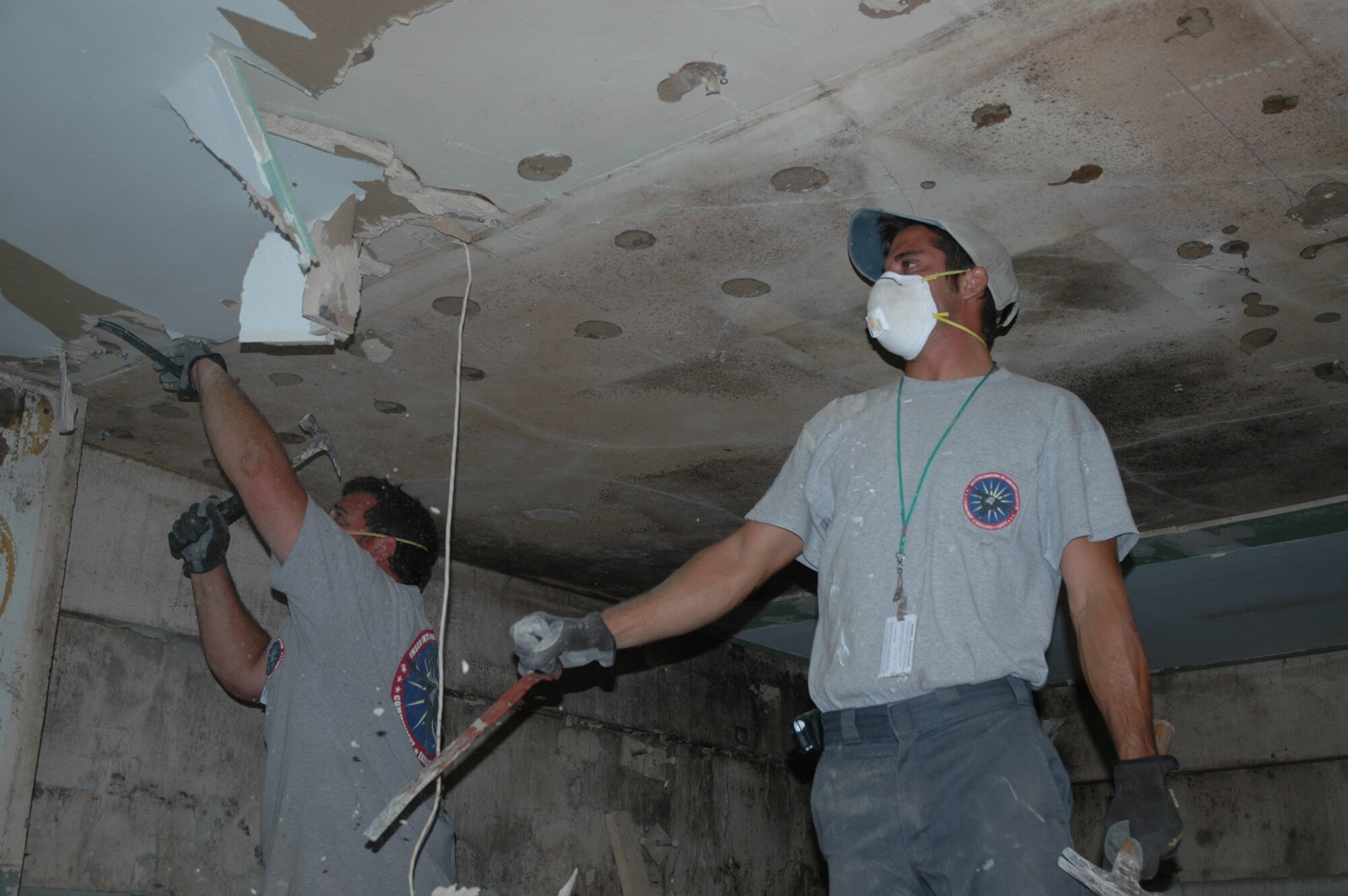 Contracters pull down old ceiling material in the men’s locker room at the Patrick Air Force Base Fitness Center July 8 in preparation for installation of shower equipment as part of a $2.5 million renovation project. (U.S. Air Force photo by Airman 1st Class David Dobrydney)