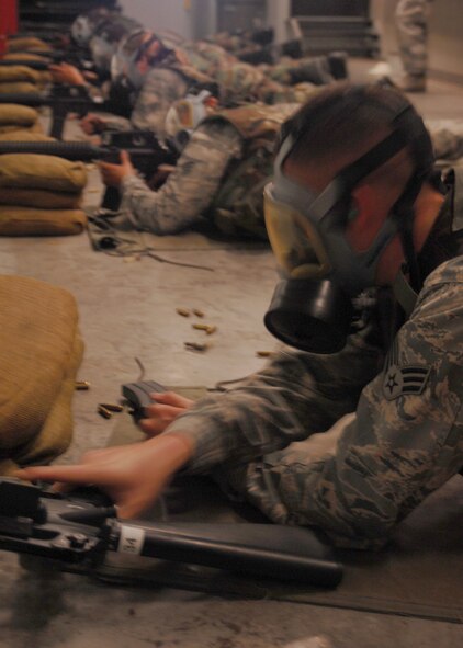 SEYMOUR JOHNSON AIR FORCE BASE, N.C. - Airmen attending the M-16 qualifying course at the combat arms training and maintenance firing range practice firing while wearing gas masks here July 2. Airmen must periodically qualify on the M-16 to remain deployable. (U.S. Air Force photo by Airman 1st Class Makenzie R. Lang) 