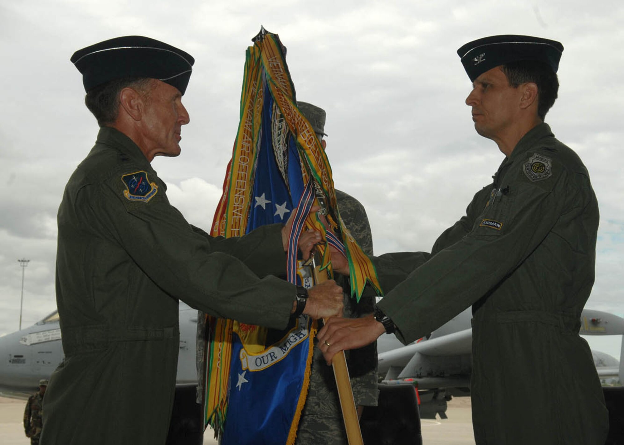 Col. Paul T. Johnson, right, receives the 355th Fighter Wing guidon from Lt. Gen. Norman Seip, 12th Air Force (Air Forces Southern) commander, during a change-of-command ceremony at the 55th Helicopter Maintenance Unit hangar yesterday. Colonel Johnson is the 48th base wing commander at Davis-Monthan. (U.S. Air Force photo by Senior Airman Jacqueline Hawkins)
