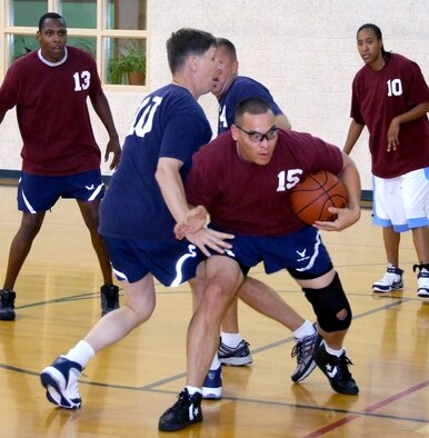 Tech Sgt. Jon Cabatit, 15, keeps Col. Richard Klumpp’s hand off the basketball during the Commander’s Challenge basketball game held Wednesday, July 9, in the reopened Fitness Center gymnasium at Vance AFB, Okla. A new air-conditioning system kept the commanders team comfortable despite a 44-38 loss to the base populous team. (U.S. Air Force photo by Terry Wasson)