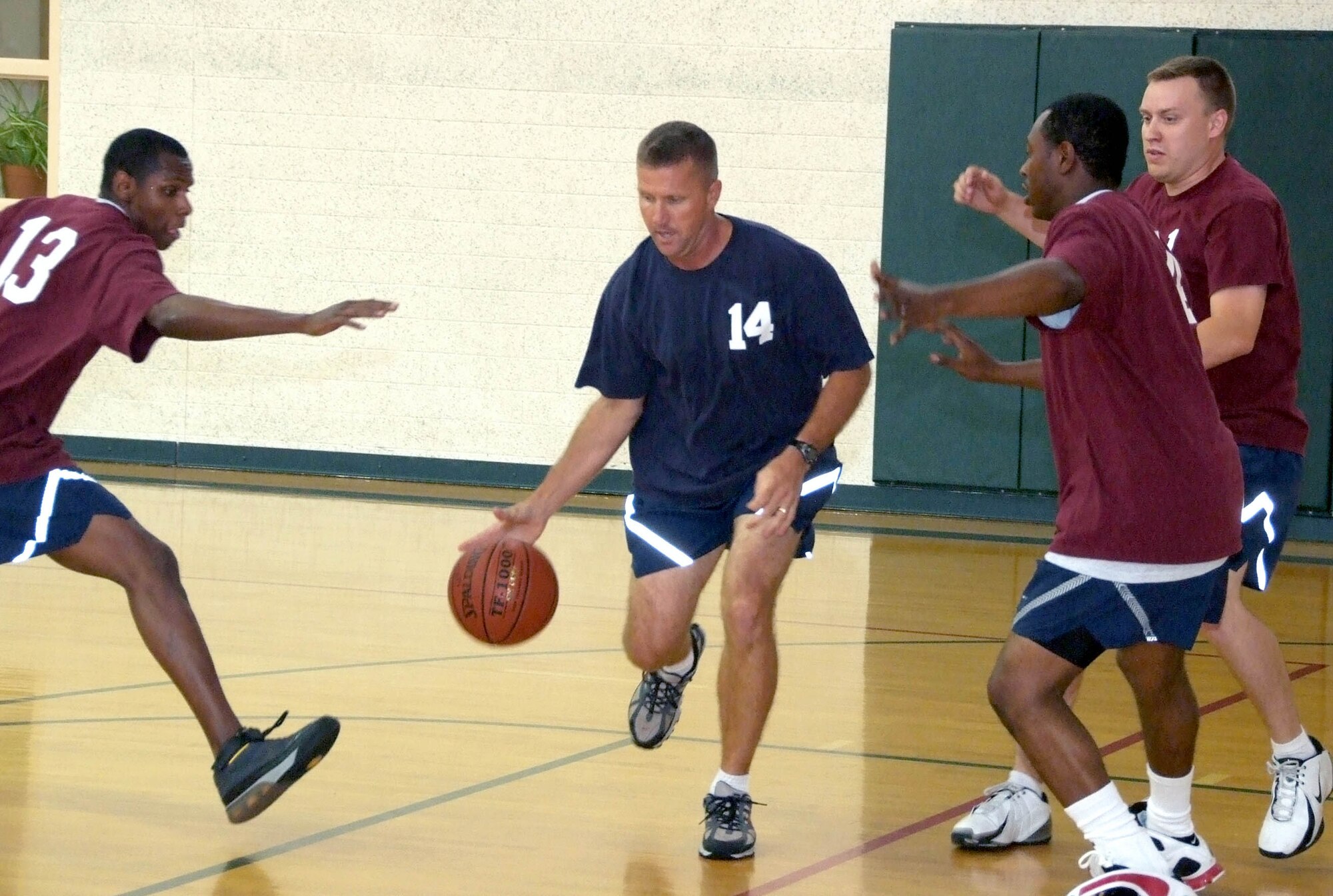 Lt. Col. Mark Batcho, 14, dribbles pass members of the base-populous team during the Commander’s Challenge basketball game held Wednesday, July 9, in the reopened Fitness Center gymnasium at Vance AFB, Okla. Even a new air-conditioning system didn’t help the commanders team. They suffered a loss of 44-38. (U.S. Air Force photo by Terry Wasson)