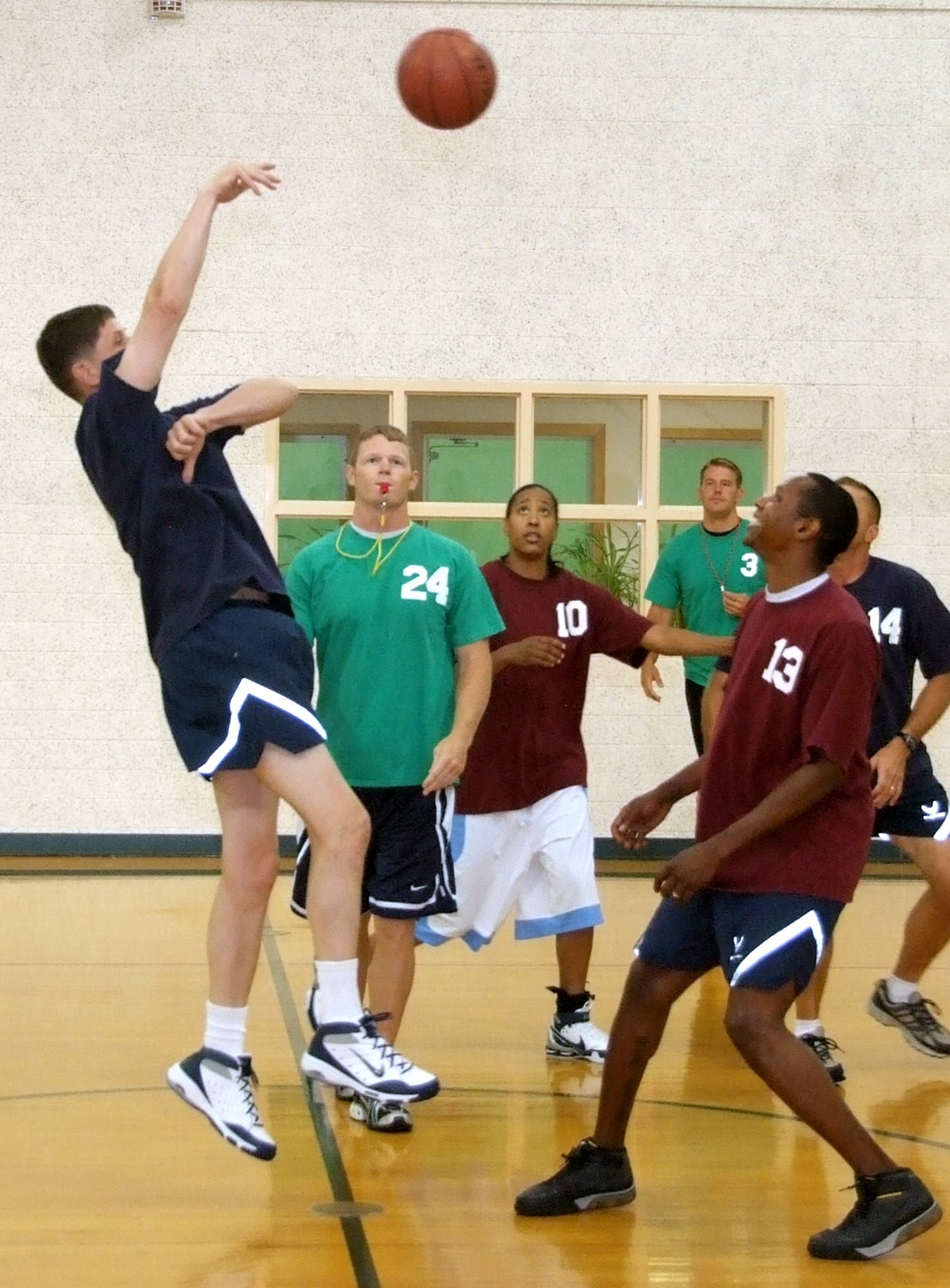 Senior Airman Larry Portwood, 13, is overshadowed by Col. Richard A. Klumpp Jr., at the tip-off of the Commander’s Challenge basketball game held Wednesday, July 9, in the reopened Fitness Center gymnasium at Vance AFB, Okla. The gym now has a new air-conditioning system. The base-populous team scored a victory over the commanders, 44-38. (U.S. Air Force photo by Terry Wasson)