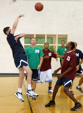Senior Airman Larry Portwood, 13, is overshadowed by Col. Richard A. Klumpp Jr., at the tip-off of the Commander’s Challenge basketball game held Wednesday, July 9, in the reopened Fitness Center gymnasium at Vance AFB, Okla. The gym now has a new air-conditioning system. The base-populous team scored a victory over the commanders, 44-38. (U.S. Air Force photo by Terry Wasson)