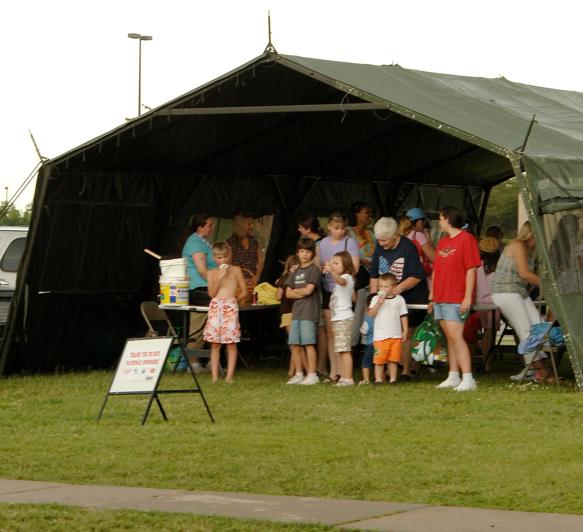 MCCONNELL AIR FORCE BASE, Kan. -- Team McConnell members wait under a tent for a passing thunderstorm to end at, July 2. The 22nd Services Squadron hosted a beach party for members of the base. (Photo by Senior Airman Laura Suttles)