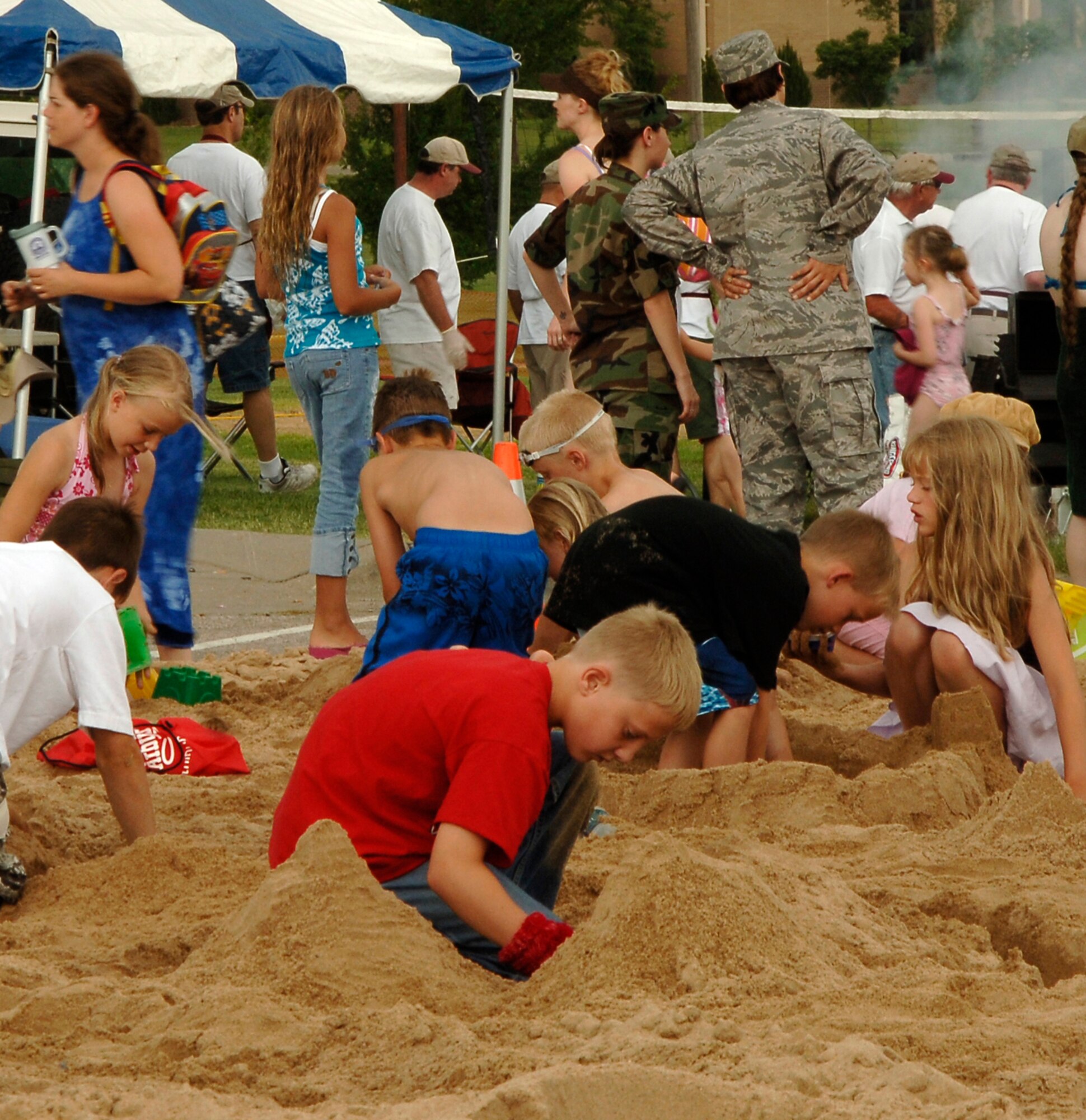 MCCONNELL AIR FORCE BASE, Kan. -- Team McConnell family members prepare for the sandcastle competition held by the 22nd Services Squadron, July 2. The 22nd SVS held various events at the Match-Up Beach Party such as volleyball, monster truck rides, watermelon seed spitting contest, sandcastle building competition and pool races. (Photo by Senior Airman Laura Suttles)