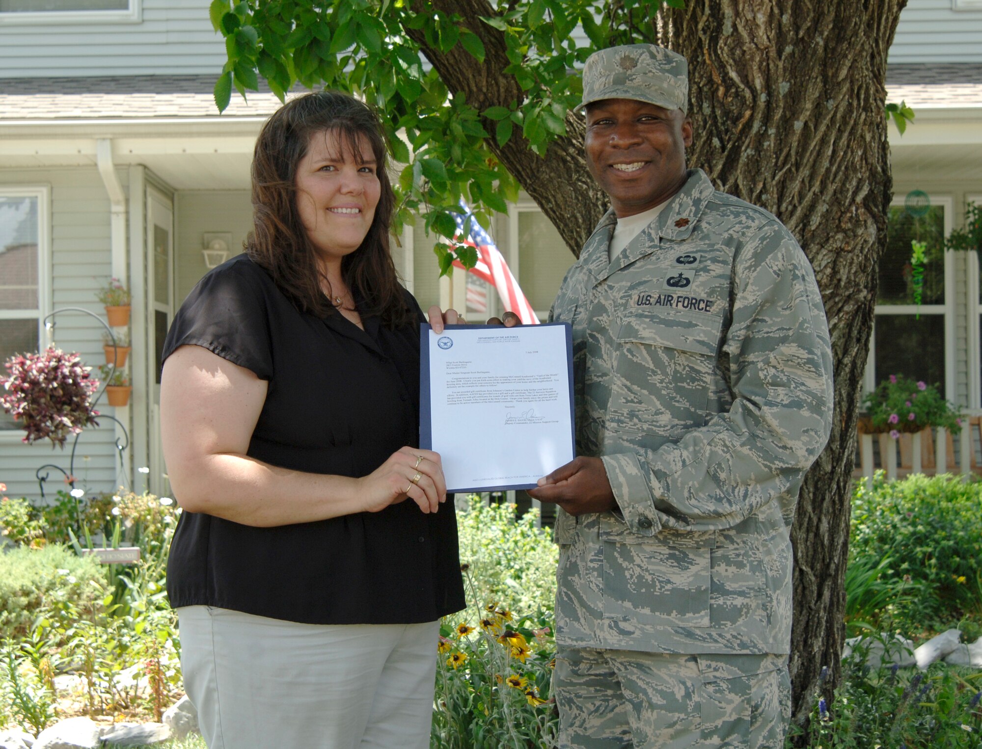 MCCONNELL AIR FORCE BASE, Kan. -- Jennifer Burlingame wife of Master Sgt. Scott Burlingame, 22nd Security Forces Squadron, is recognized by Maj. James Davis, 22nd Contracting Squadron, July 7 for winning the yard of the month, for the month of June. Mrs. Burlingame was awarded a fountain for winning yard of the month. (Photo by Senior Airman Roy Lynch)