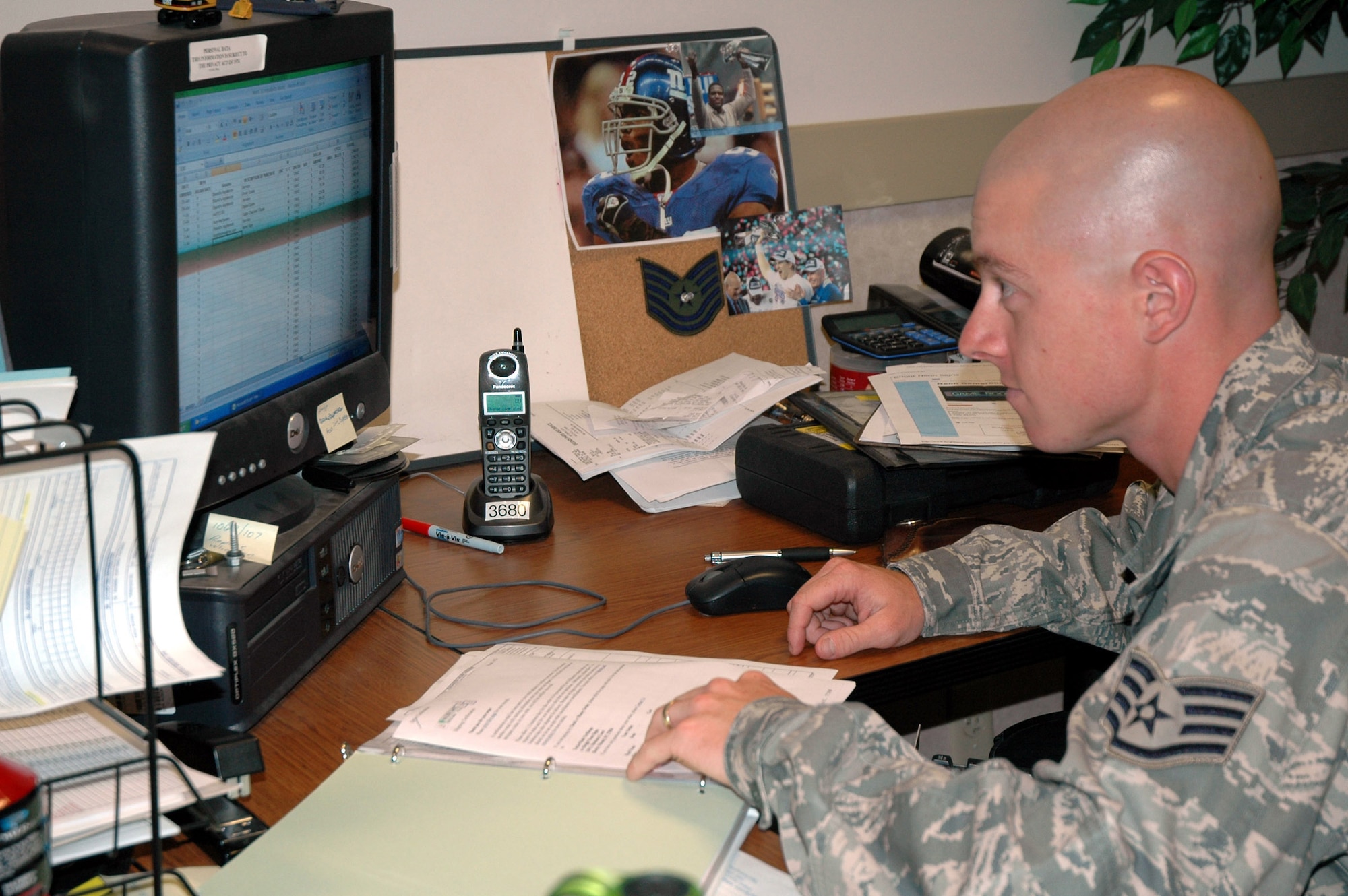 Staff Sgt. Jason Ward looks over the Central Dorm Management Office's financial statement for the month. As a dorm manager, he is also the team's resource advisor and government purchase card holder. (U.S. Air Force photo/Valerie Mullett)