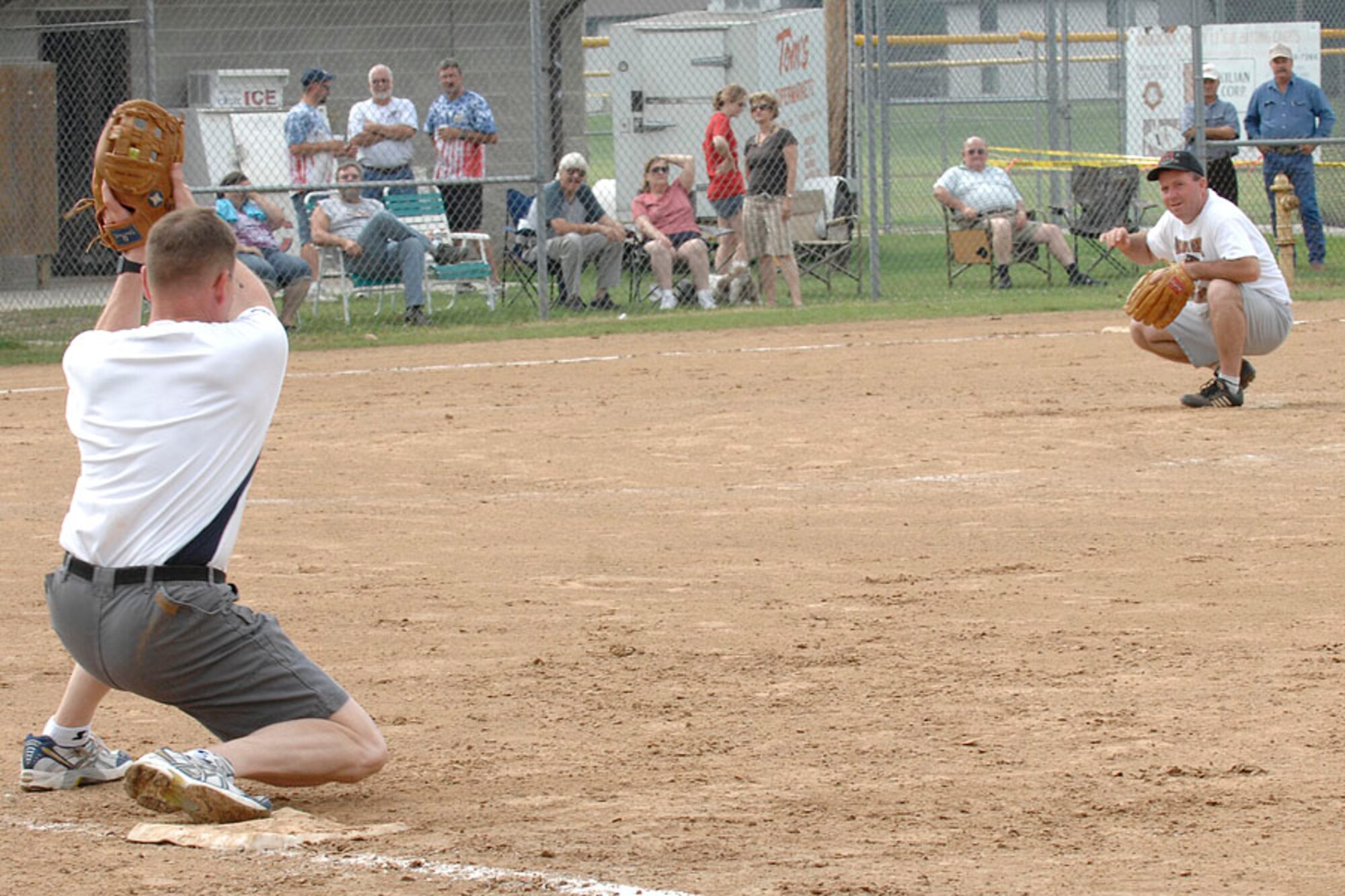 SCOTT AIR FORCE BASE, Ill. -- Col. Al Hunt, 375th Airlift Wing commander (right) looks on as Chief Master Sgt James Suttles, 375th Airlift Wing Command Chief, records an out at first base during the traditional 4th of July softball game between JTF Scott and citizens from the city of Mascoutah. 
