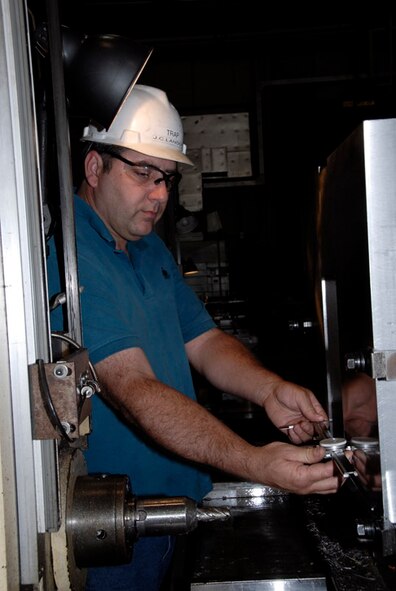 James “Trapper” Landon, Aerospace Testing Alliance machinist in the Model Shop, is checking the size of a recessed pocket on the bottom of a plate that holds an adjustable rake for testing flames. (Photo by Rick Goodfriend)