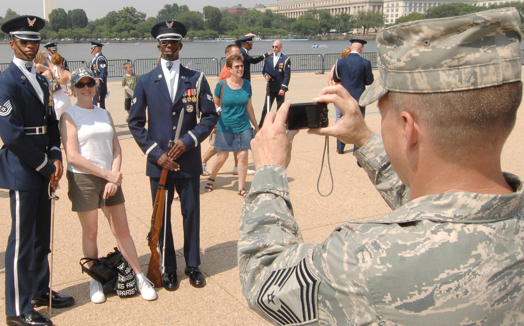 Chief Master Sgt. Harold Hutchison, 11th Operation Group, takes a snapshot of a spectator and two members of U.S. Honor Guard Drill Team after their performance as part of the team's Summer Drill Series July 8 at the Jefferson Memorial in Washington. The team will perform around the National Capitol Region until July 29. For more information about the 2008 performances, logon to www.honorguard.af.mil/drillteam/. (U.S Air Force photo by Senior Airman Alexandre Montes)