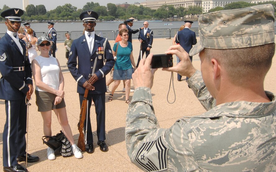 Chief Master Sgt. Harold Hutchison, 11th Operation Group, takes a snapshot of a spectator and two members of U.S. Honor Guard Drill Team after their performance as part of the team's Summer Drill Series July 8 at the Jefferson Memorial in Washington. The team will perform around the National Capitol Region until July 29. For more information about the 2008 performances, logon to www.honorguard.af.mil/drillteam/. (U.S Air Force photo by Senior Airman Alexandre Montes)