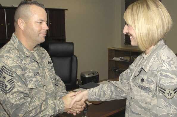 Chief Master Sgt. Randall Raper, 11th Wing command chief, talks to Airman 1st Class Suzanne Reis, 11th Wing, about events for the day July 10 in the 11th Wing command section. (U.S. Air Force photo by Airman 1st Class Sean Adams)
