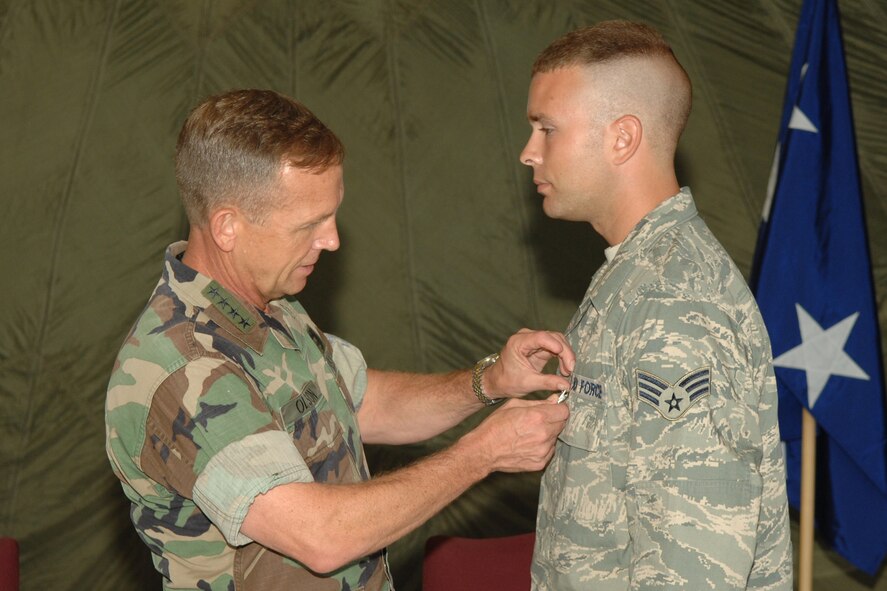 Adm. Eric T. Olson, commander of the United States Special Operations Command, pins a Purple Heart on Senior Airman Joshua Bellin July 8. Airman Bellin, 1st Special Operations Logistics Readiness Squadron, received the medal for injuries he received when an improvised explosive device struck his vehicle in January 2008 in Iraq. (U.S. Air Force photo/Senior Airman Stephanie Jacobs)