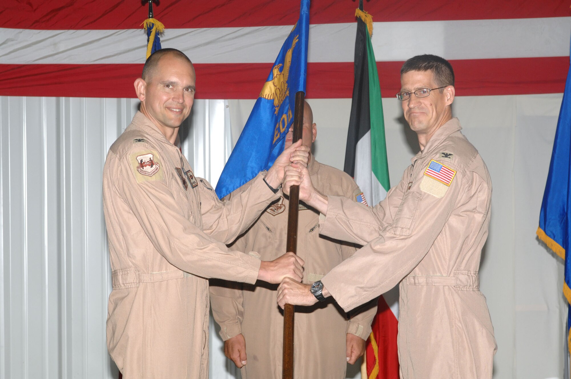 SOUTHWEST ASIA -- Col. David Miller accepts the guide-on from Col. Cameron Torrens, 386th Air Expeditionary Wing commander, as he assumed command of the 386th Expeditionary Operations Group from Col. Gary Goldstone during a change of command ceremony here July 8. Colonel Goldstone is headed to Scott Air Force Base, Ill. (U.S. Air Force photo/Tech. Sgt. Raheem Moore) 
