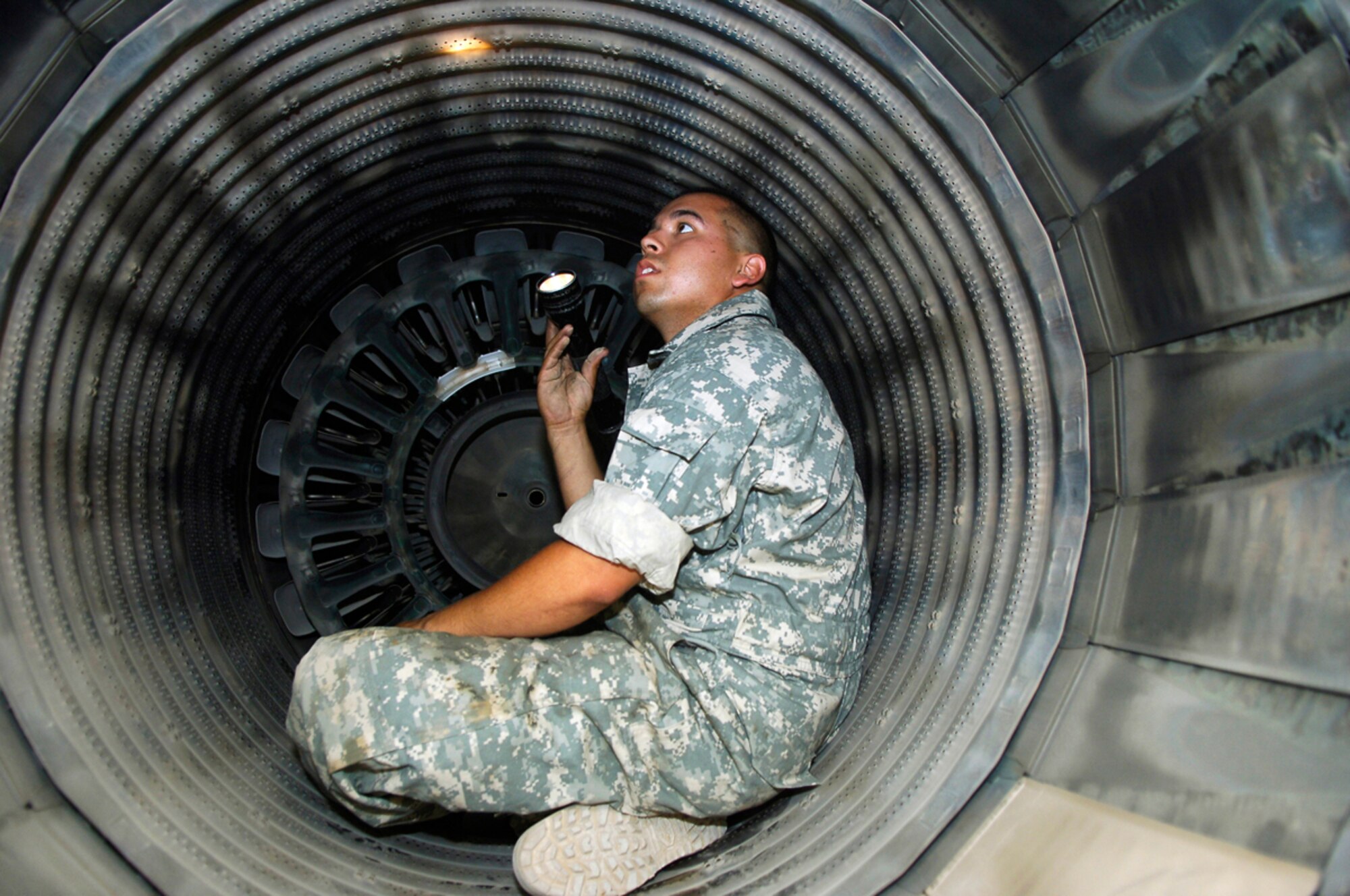 JOINT BASE BALAD, Iraq -- Senior Airman Andrew Molina, an engine mechanic assigned to the 332nd Expeditionary Maintenance Squadron Tiger Aircraft Maintenance Unit, inspects the liner of an augmenter -- commonly known as an afterburner -- for missing coating and rivets here July 7. Each jet assigned to the unit must be inspected daily to ensure it's mission-ready at all times. Airman Molina is deployed from the New York Air National Guard. (U.S. Air Force photo/Staff Sgt. Mareshah Haynes)