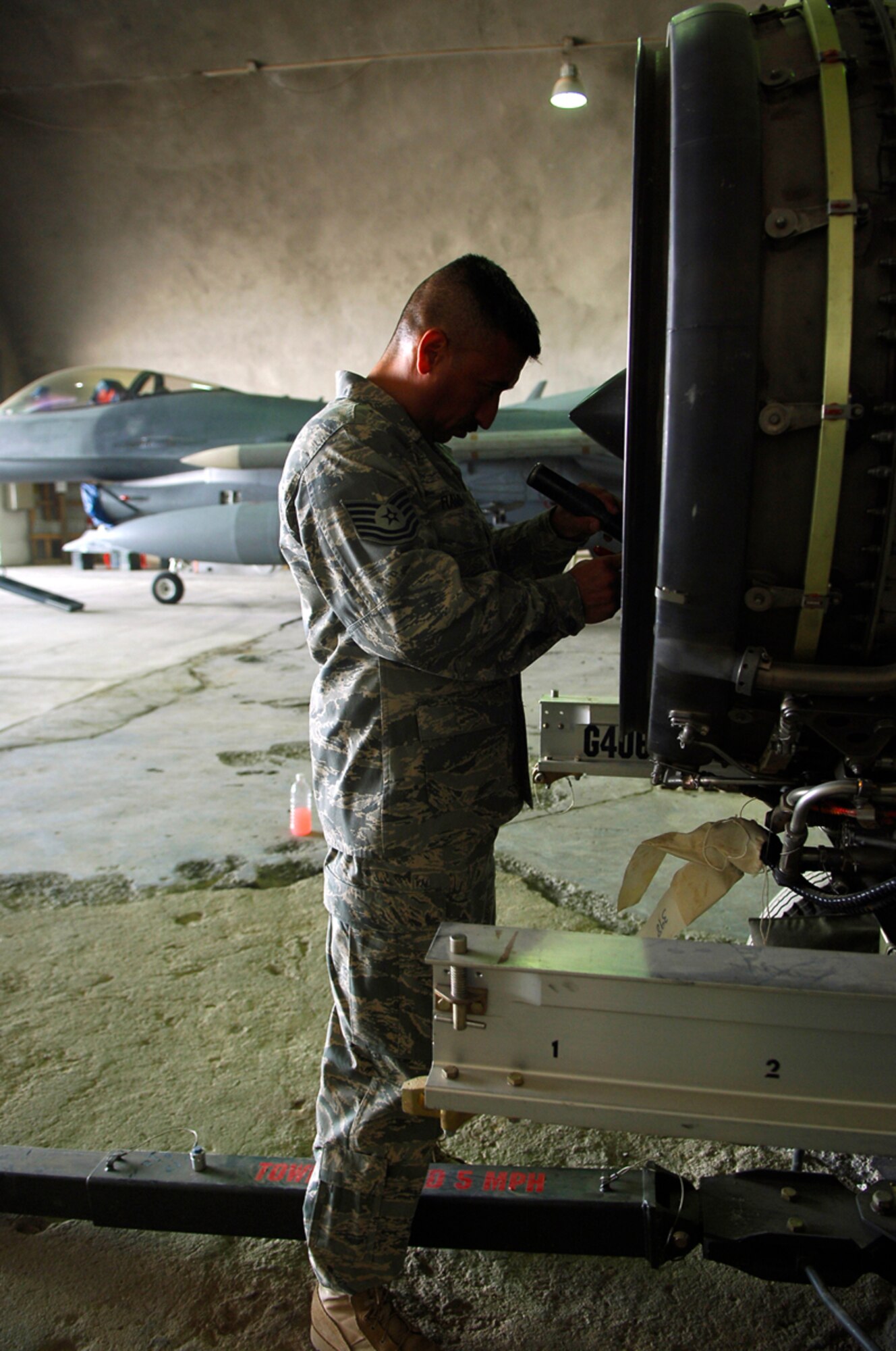 JOINT BASE BALAD, Iraq -- Tech. Sgt. Juan Ramon, a 332nd Expeditionary Maintenance Squadron jet engine mechanic assigned to the Tiger Aircraft Maintenance Unit, inspects the inlet fan blades of an F-16 Fighting Falcon engine for nicks and scratches here July 7. Foreign object debris damage prevention is critical to maintaining the jets' engines. One small rock a piece of trash could cause thousands of dollars in damage to an engine. (U.S. Air Force photo/Staff Sgt. Mareshah Haynes)
