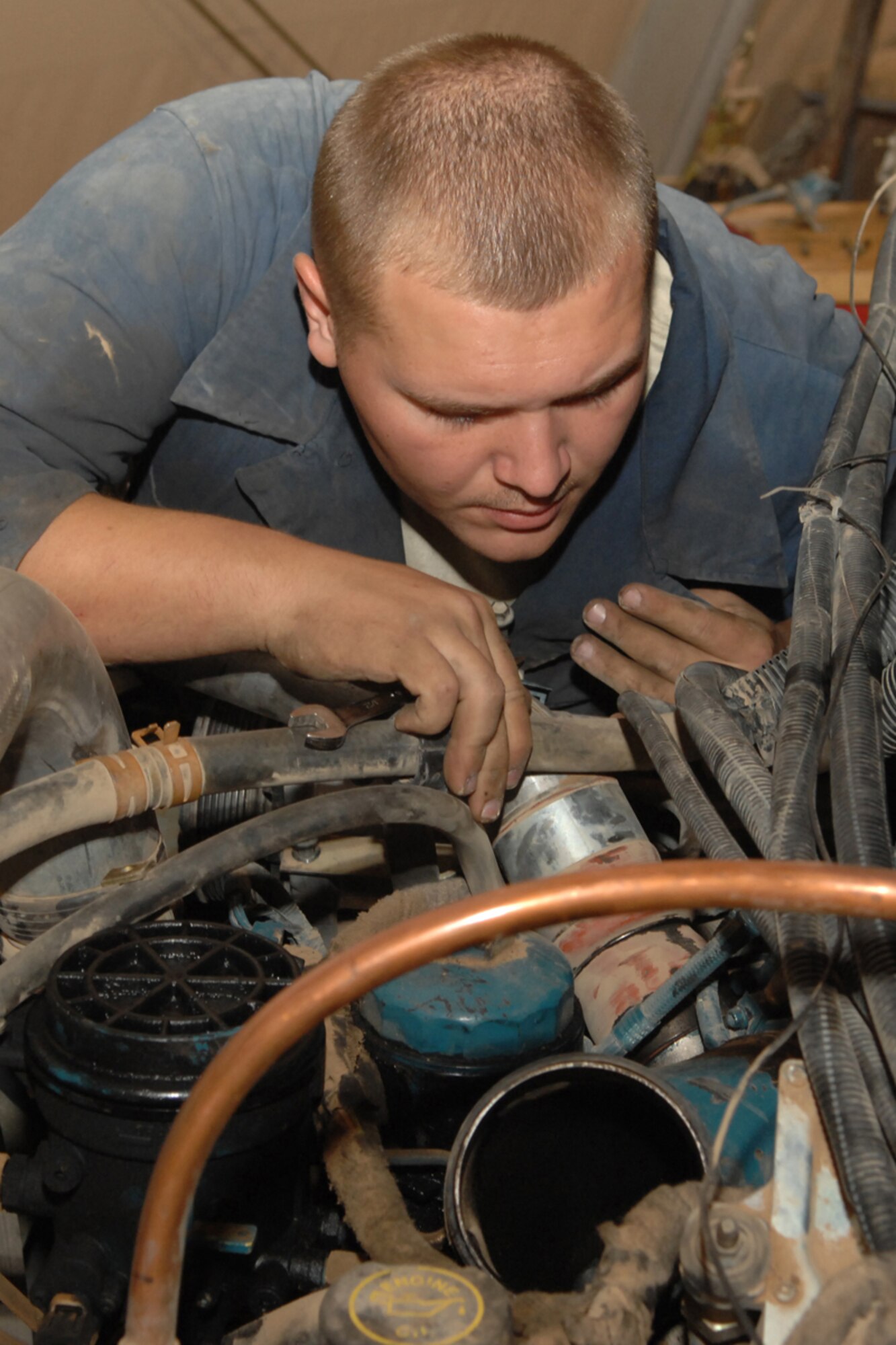 KIRKUK REGIONAL AIR BASE, IRAQ -- Senior Airman Isiah Weimer(left), 506th Expeditionary Logistics Readiness Squadron, prepares to remove an engine from a Sweeper with the guidance of Tech. Sergeant Shawn Courts at the vehicle maintenance shop July 10.  Senior Airman Weimer is deployed from Kadena Air Base, Japan and Sergeant Courts is from Misawa AB, Japan.  The 506 ELRS pushes out approximately 70 vehicles a week and supports the base 24 hours a day seven days a week. (U.S. Air Force photo/Airman 1st Class Randi Flaugh) 
