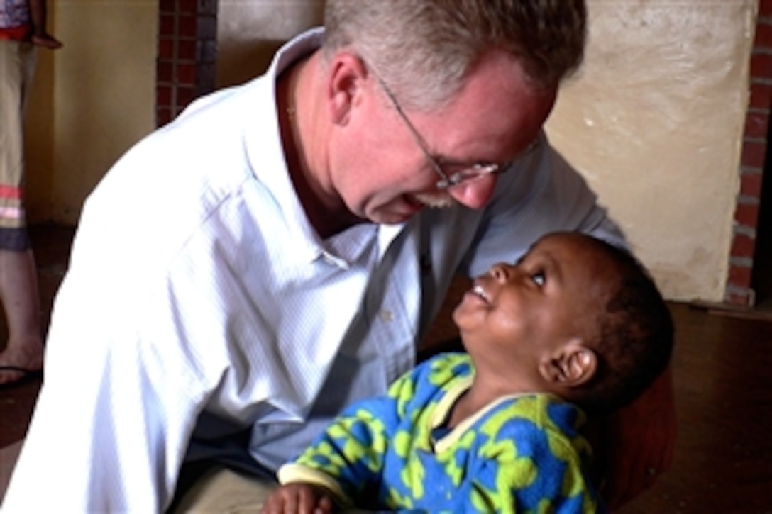 U.S. Air Force Lt. Col. (Dr.) Kirk A. Milhoan, a pediatric cardiologist,  spends a moment with Simon, who was brought to a Zambia orphanage very close to death, July 8, 2008. With the care and treatment he received there, Simon was able to once again be a vibrant and energetic child. The orphanage in Kitwe, Zambia, was founded in 2003 with the help of Dr. Milhoan who is assigned to the 59th Maternal/Child Care Squadron.