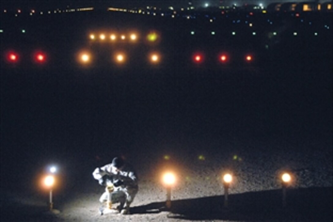 U.S. Air Force Staff Sgt. Samnang Lay replaces a bulb on an approach light on Joint Base Balad, Iraq, July 5, 2008. Lay is assigned to the 332nd Expeditionary Civil Engineer Squadron. Illumination of the airfield at night is critical to the safety of aircraft, personnel and cargo at the busiest single runway operation in the Department of Defense. 