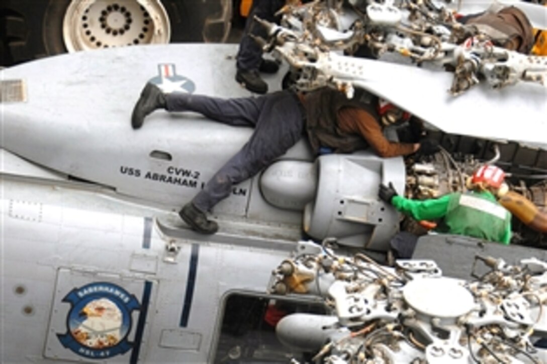 U.S. Navy personnel perform pre-flight maintenance on an SH-60B Seahawk aboard the aircraft carrier USS Abraham Lincoln, North Arabian Sea, July 9, 2008. The USS Lincoln is deployed to the U.S. 5th Fleet area of responsibility supporting maritime security operations. 