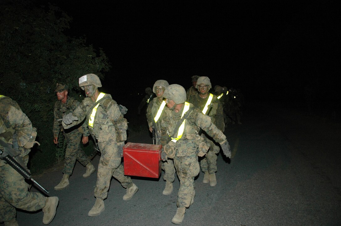 Recruits Matthew L. Earier and Jonathon R. George, Platoon 3250, carry a 40mm ammunition can during the night re-supply hike July 10 at Edson Range, Marine Corps Base Camp Pendleton, Calif. The four-mile hike was part of the Crucible, a 54-hour training event in which recruits hike 40 miles and stop at different stations to conduct team exercises.