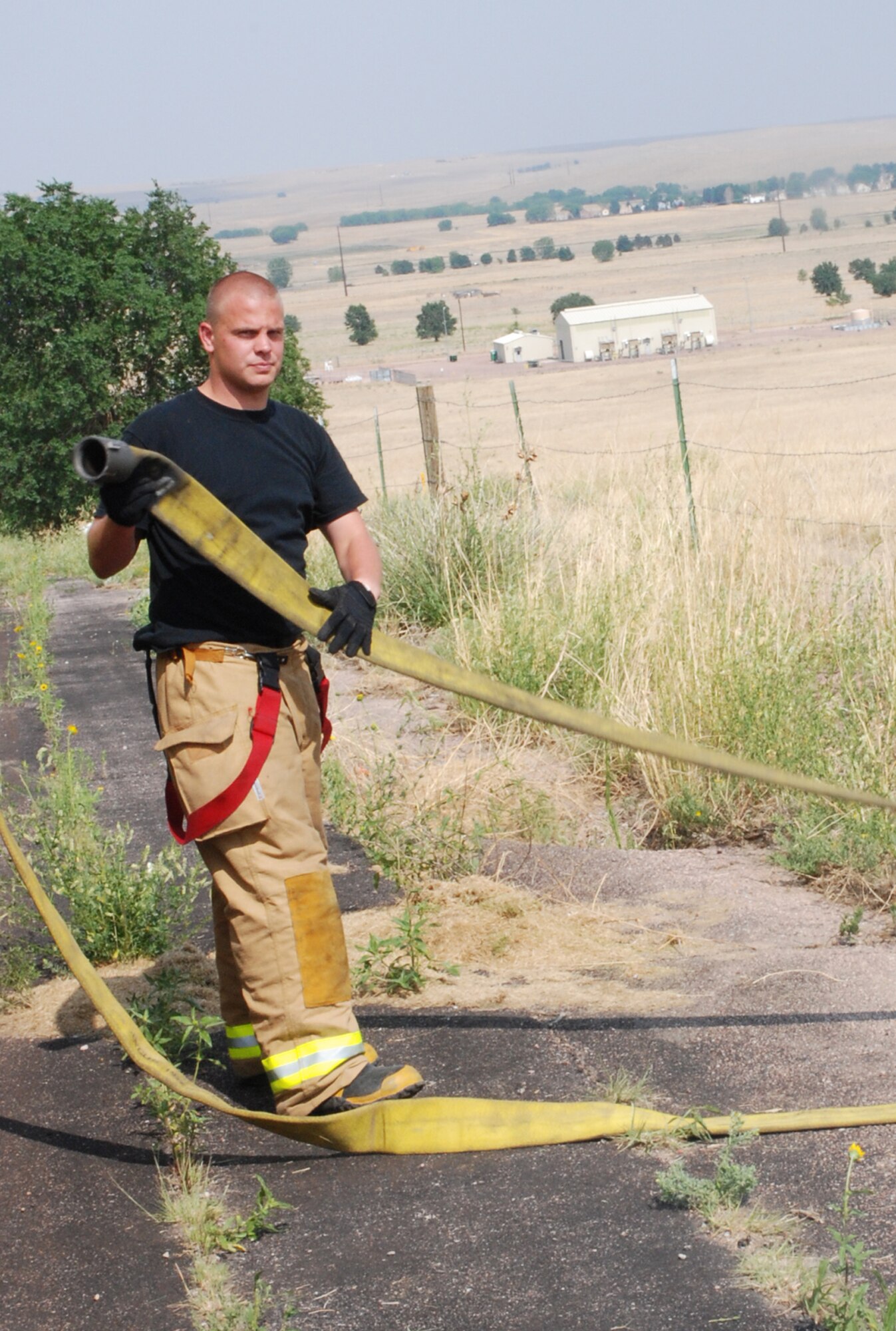 Airman Brandon Mcgath, 21st Civil Engineer Squadron Fire Protection Flight firefighter, prepares a hose from a Peterson’s 5,000 gallon water tender to refill one of several fire engines responding to a fire south of the runway July 11 outside Peterson Air Force Base, Colo. The fire, which occurred outside of Peterson, required three fire departments to extinguish. Peterson firefighters are trained to suppress fires involving aircraft, buildings, automobiles and wild land. (U.S. Air Force Photo/Staff Sgt. Jessica Switzer)