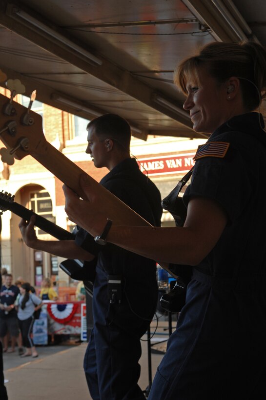 (Front) Master Sgt. Lori Weber, Night Wing bass guitarist, and (back) Staff Sgt. Clint Whitney, Night Wing guirtarist, entertain the crowd by performing various songs on 7th Street in Rapid City, S.D., July 10. Night Wing is part of the Heartland of America Band from Offutt Air Force Base, Neb. (US Air Force photo/Airman Corey Hook)