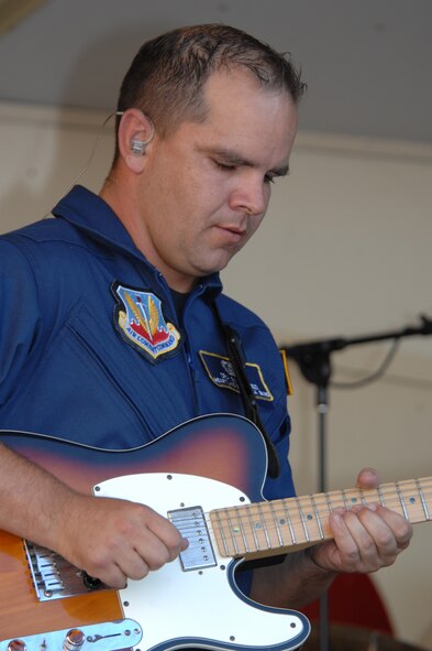 Senior Airman Ryan Manzi, Night Wing lead guitarist, entertains the crowd with his performance skill during Summer Night held on 7th Street in Rapid City, SD July 10.  Night Wing performed various songs at the event to increase patriotism and military appreciation. (US Air Force photo/Airman Corey Hook)