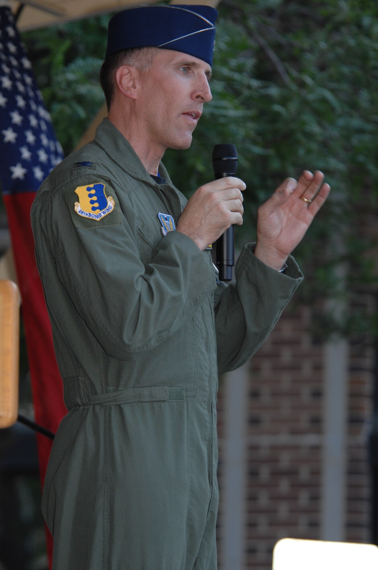 Col. Scott Vander Hamm, 28th Bomb Wing commander, speaks to a crowd during Summer Nights, an event held every Thursday on 7th Street in Rapid City, S.D., July 10. This particular Thursday honored military members with entertainment provided by the Heartland of America Band's Night Wing ensemble. (US Air Force photo/Airman Corey Hook)