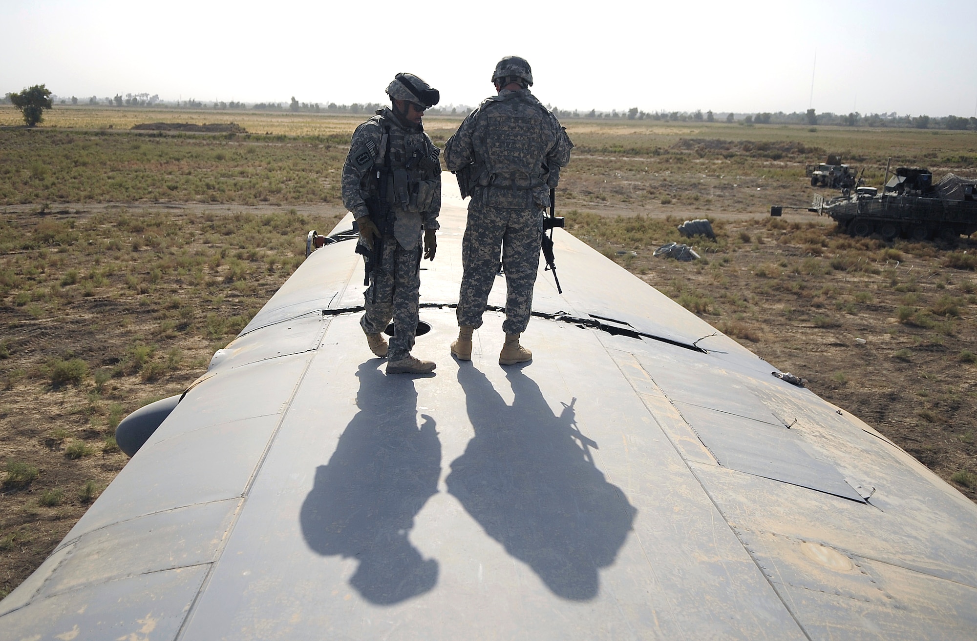 Senior Master Sgt. Pervis King, left, and Staff Sgt. Joshua Langdon from the 447th Air Expeditionary Group's Explosive ordnance disposal team inspect explosive charges placed around the wings of the of a C-130 Hercules aircraft that are designed to divide the plane into smaller sections so it can be moved July 7 in Baghdad, Iraq. The C-130 made an emergency landing in a field north of the Baghdad International Airport shortly after take-off on June 27. (U.S. Air Force photo/Tech. Sgt. Jeffrey Allen)