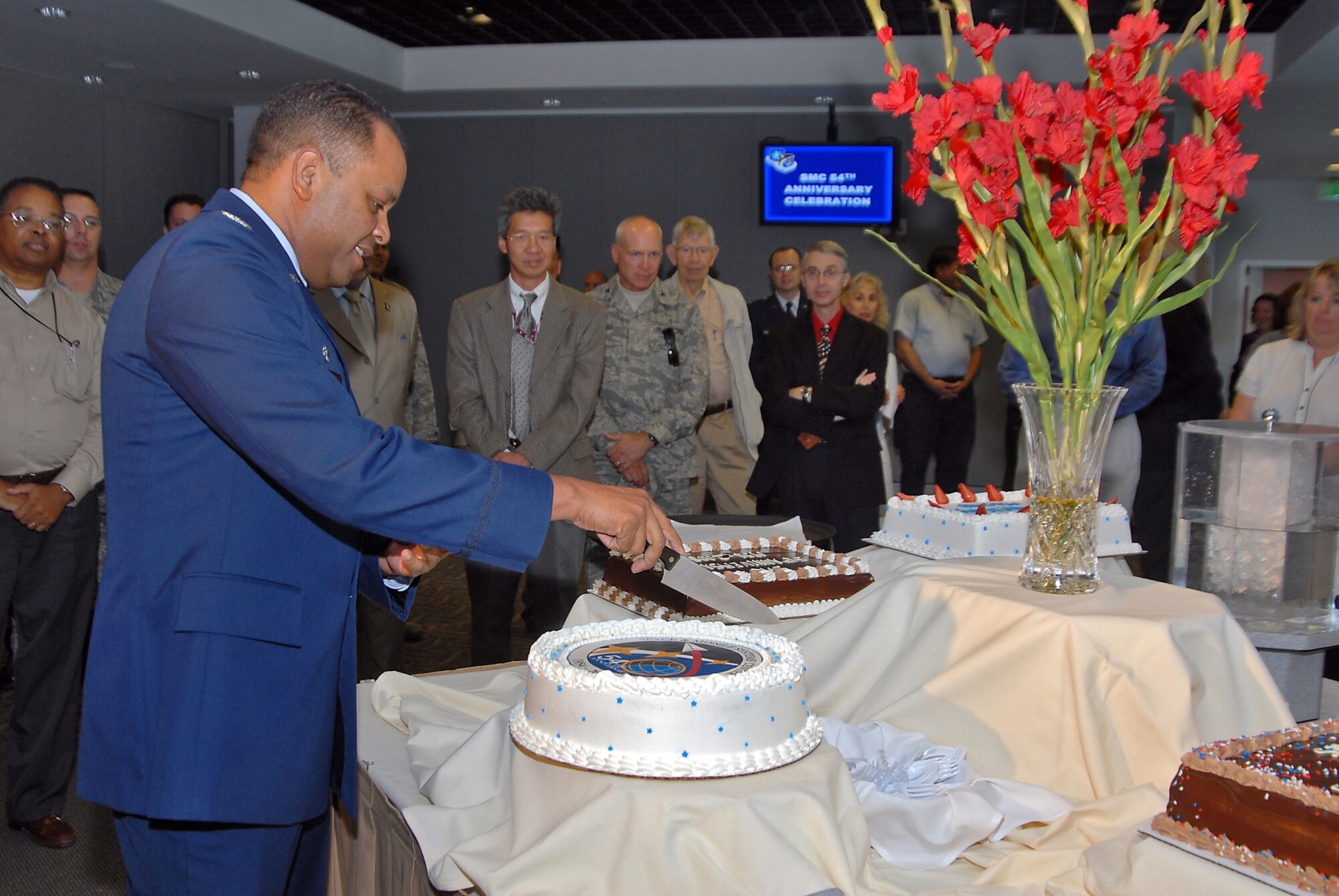 Col. Samuel Greaves, SMC Military Satellite Communications Systems Wing commander, cuts the cake at a ceremony to mark SMC's 54th birthday, July 1. Approximately 200 Los Angeles AFB military and civilian personnel attended the event. (Photo  by Joe Juarez)
