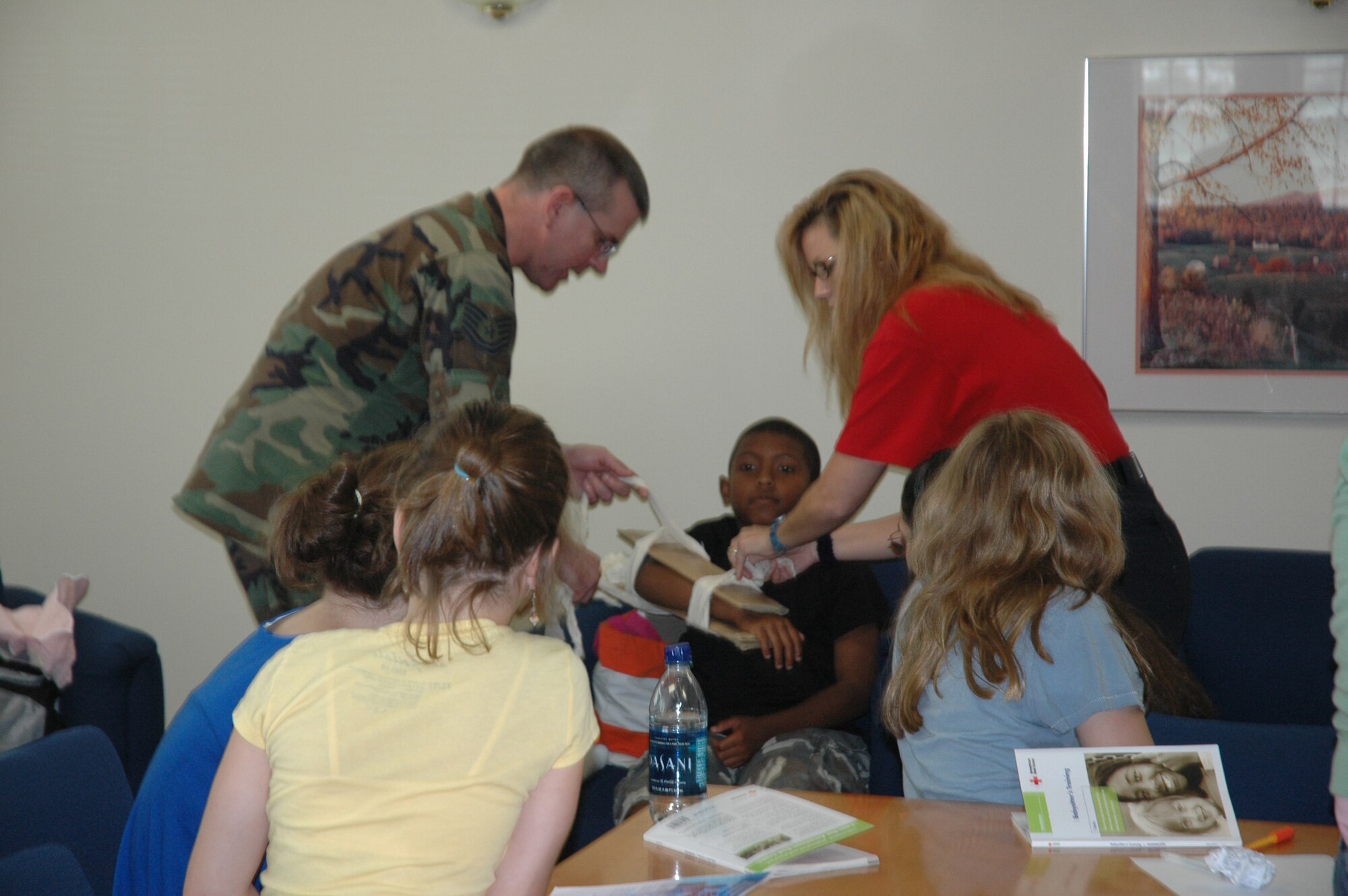 WESTOVER AIR RESERVE BASE, Mass. -- Master Sgt. Matt Dallachie,439th AMDS, and Certified Health and Safety Instructor Nikki Linder demonstrate proper securing and bandaging of a young volunteer at the Babysitter's Training Course at the Family Readiness Center at Westover Air Reserve Base. A program offered by Westover to Miltary, DOD Civilian and Contractor's dependents, this two-day course offers hands-on activities, interactive video and lively discussions that teaches young people how to care for young children, handle emergencies such as injuries, illnesses and household accidents, be good leaders and role models. 