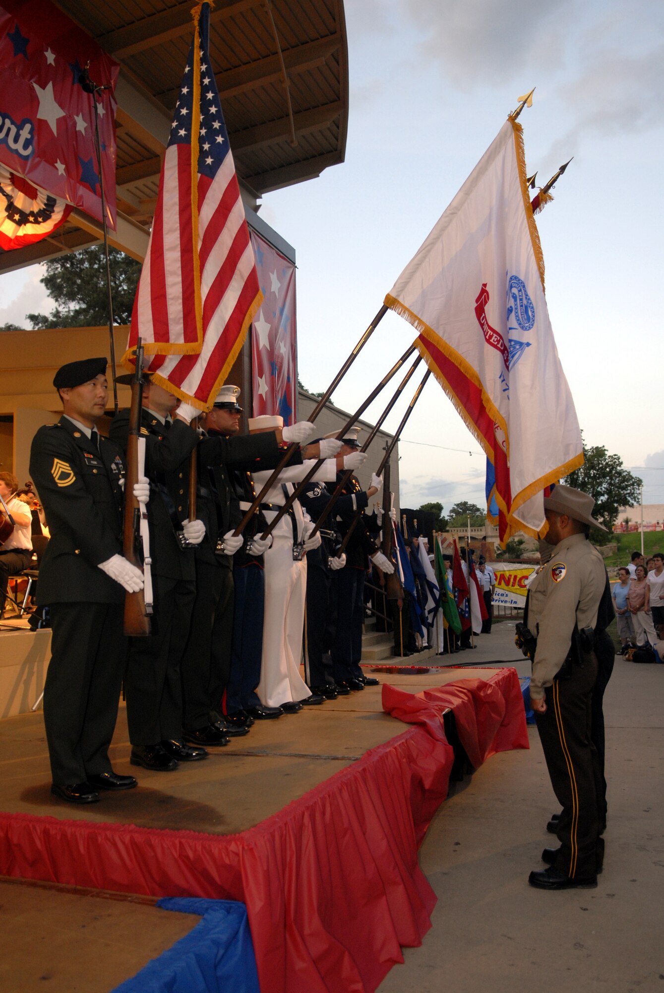Members of the Goodfellow Air Force Base Joint Color Guard present the colors during opening ceremonies at the July 3rd Pops Concert as San Angelo Police Department representatives render a salute. (U.S. Air Force photo by Senior Airman Kamaile Chan)
