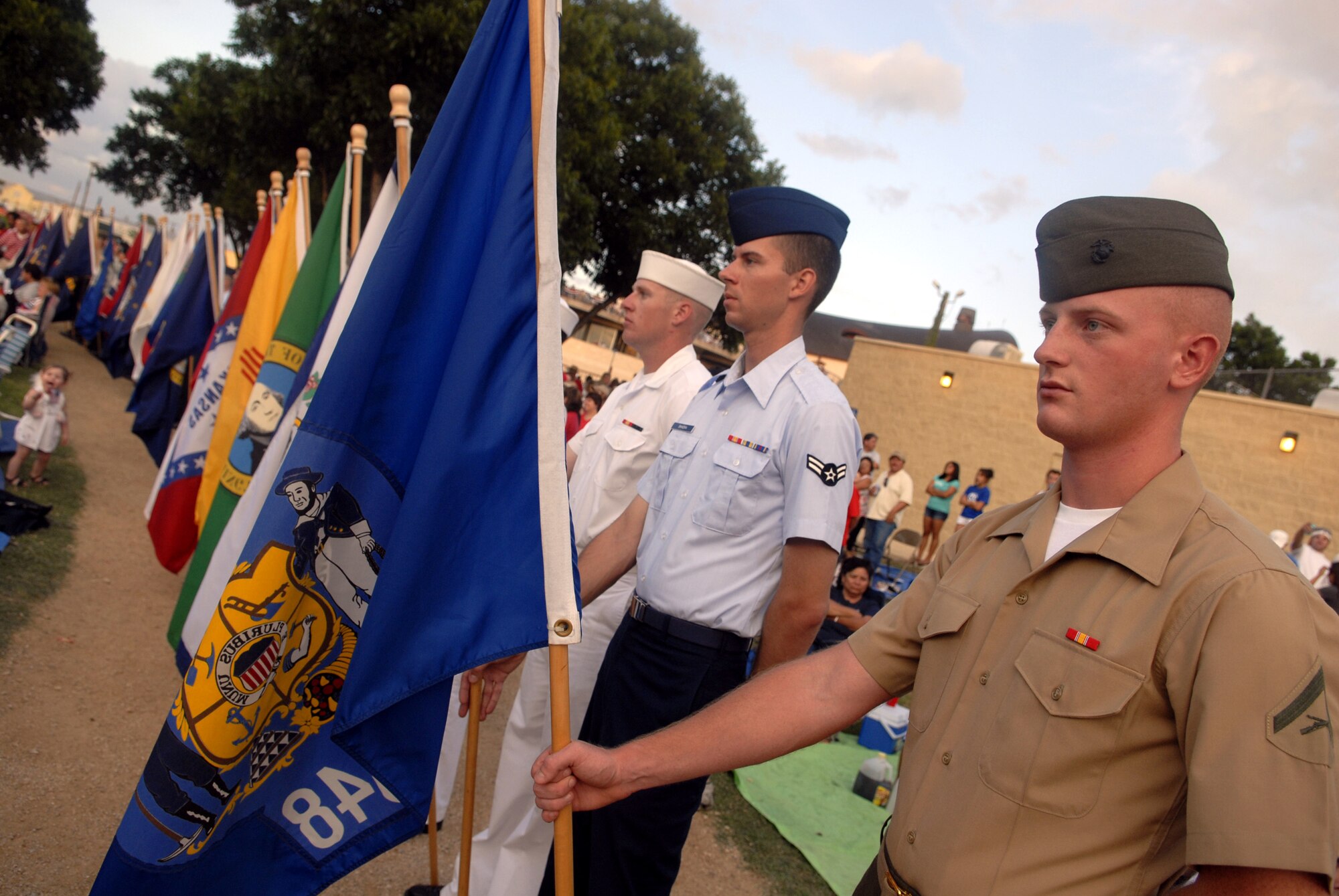 Lance Cpl. Jacob McKvinchey participates in the opening ceremonies at the July 3rd Pops Concert. Goodfellow Air Force Base students and permanent party members started the event with a parade of flags and a flyover by a flight of four T-37s from Sheppard Air Force Base, Texas. (U.S. Air Force photo by Senior Airman Kamaile Chan)