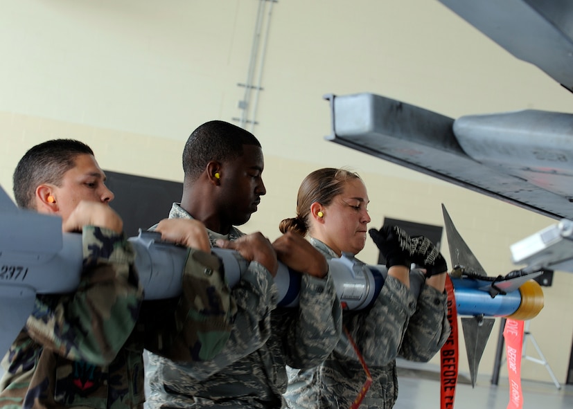 MOODY AIR FORCE BASE, Ga. -- Staff Sgt. Jonathan Flores, Staff Sgt. Harrison Ragin and Senior Airman Kimberly Brown, 23rd Aircraft Maintenance Squadron weapons load crew members, load an AIM-9 heat-seeking air-to-air missile onto an A-10C Thunderbolt II during the base's first-ever A-10C load-crew of the quarter competition here July 11. The crew won the competition for the 75th Aircraft Maintenance Unit and will now compete against the other quarterly winners in January for the title of Moody's load crew of the year. (U.S. Air Force photo by Airman 1st Class Brittany Barker)