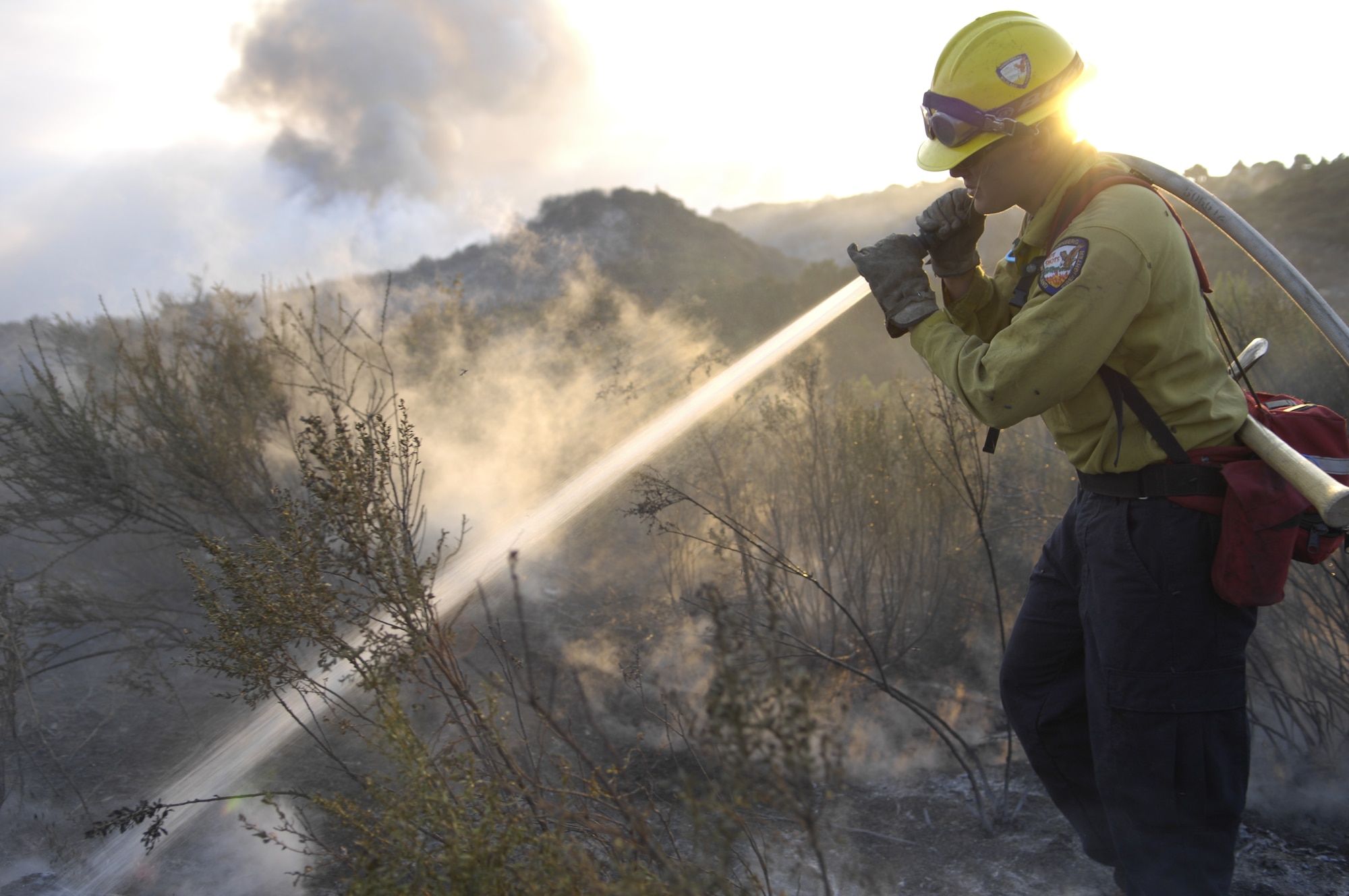 SANTA BARBARA, Calif. -- Marissa Halbeisen, a firefighter with Vandenberg Air Force Base 30th Civil Engineer Squadron, sprays the ground with fire retardant to prevent it from reigniting.  The VAFB firefighters support the local community by helping fight the Santa Barbara wildland fires.  Team V firefighters are the only firefighters in the Air Force trained for wildland fires.  (U.S. Air Force photo/Airman 1st Class Andrew Lee)