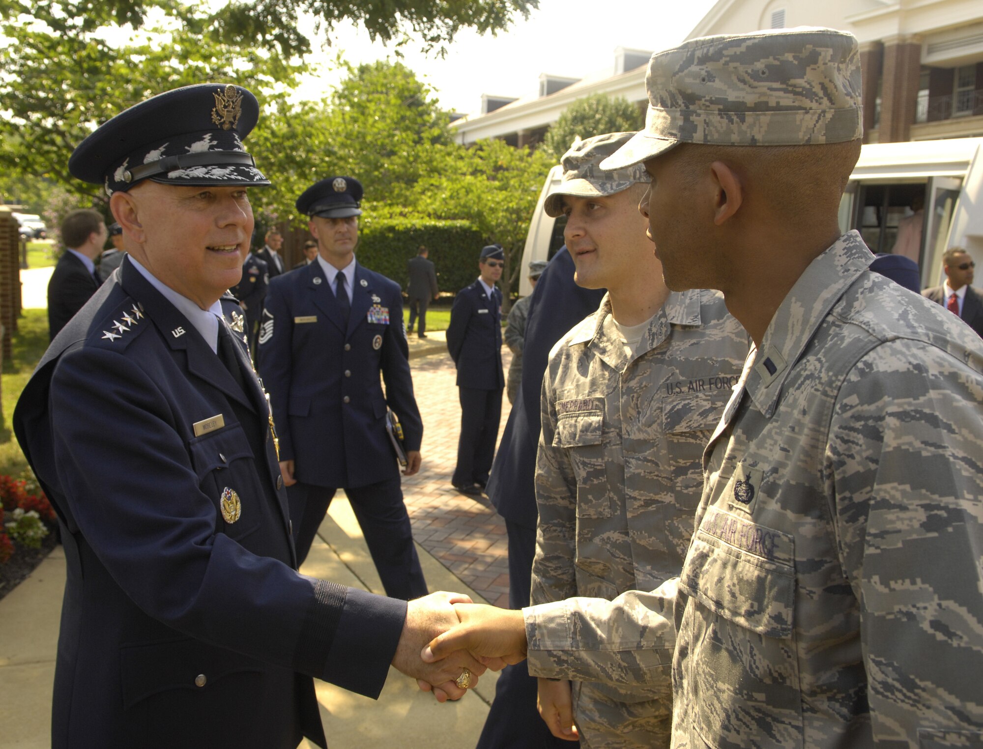 Gen. T. Michael Moseley, Air Force chief of staff, shakes the hand of 1st Lt. Harvey Catchings, 11th Wing executive officer, following the general's retirement ceremony July 11. The event took place on the Bolling Air Force Base, D.C., Ceremonial Lawn. Looking on is Staff Sgt. Aaron P. Sheppard, 11th Wing. (U.S. Air Force photo by A1C Sean Adams).