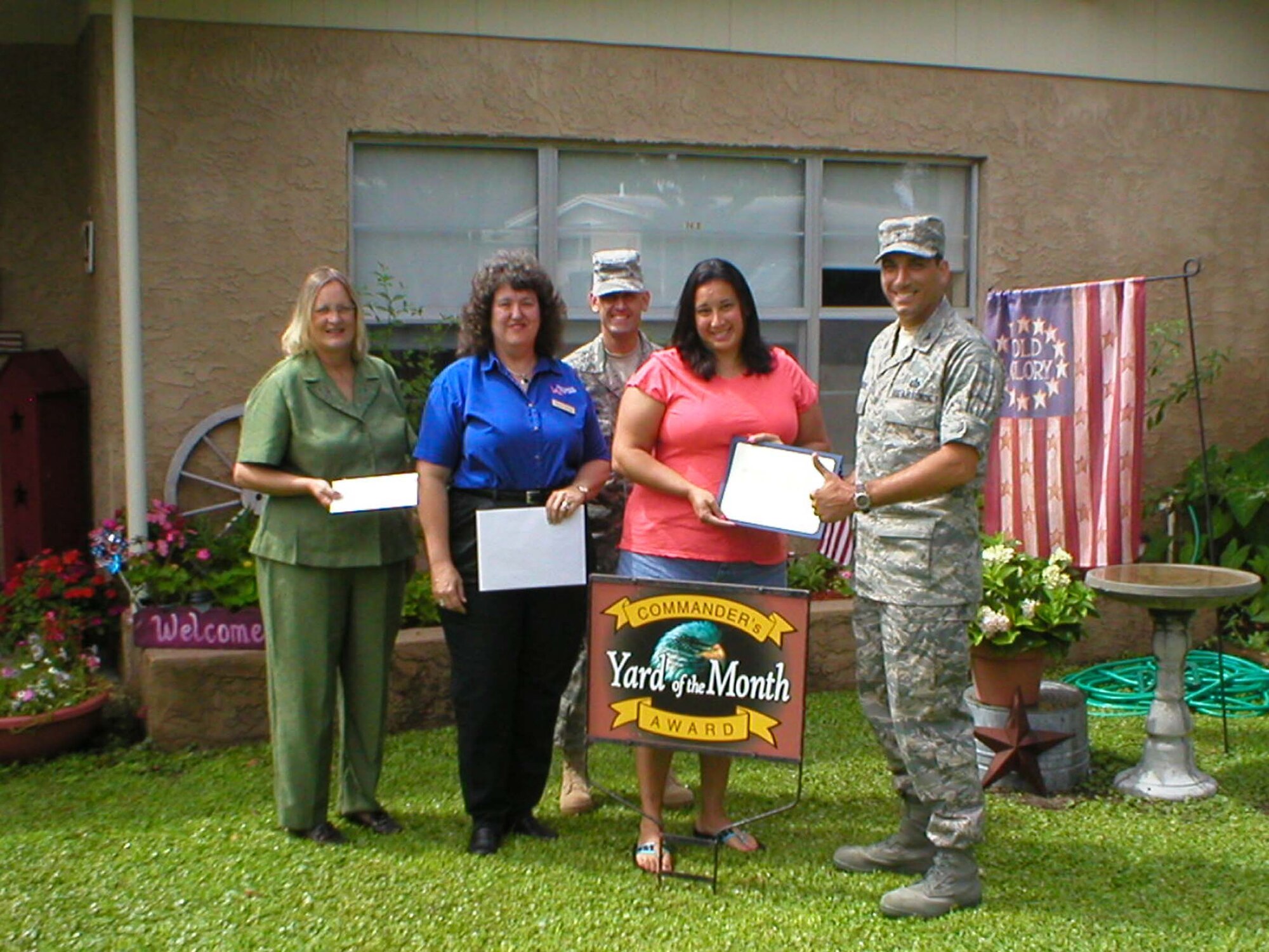 EGLIN AIR FORCE BASE, Fla. -- Col. Rick LoCastro, 96th Air Base Wing vice commander, presents a certificate to  Kelly Garrison for the Yard of the Month competition. Her husband, Major Robert Garrison, is on temporary duty.  Mrs. Garrison also received two $25 gift cards. Also pictured are (l-r) Kathy Lawhon, housing flight chief; Sherry Harlow, Eglin Federal Credit Union and 96th ABW Command Chief Troy Engholm.  (USAF photo by Timothy Crews)  