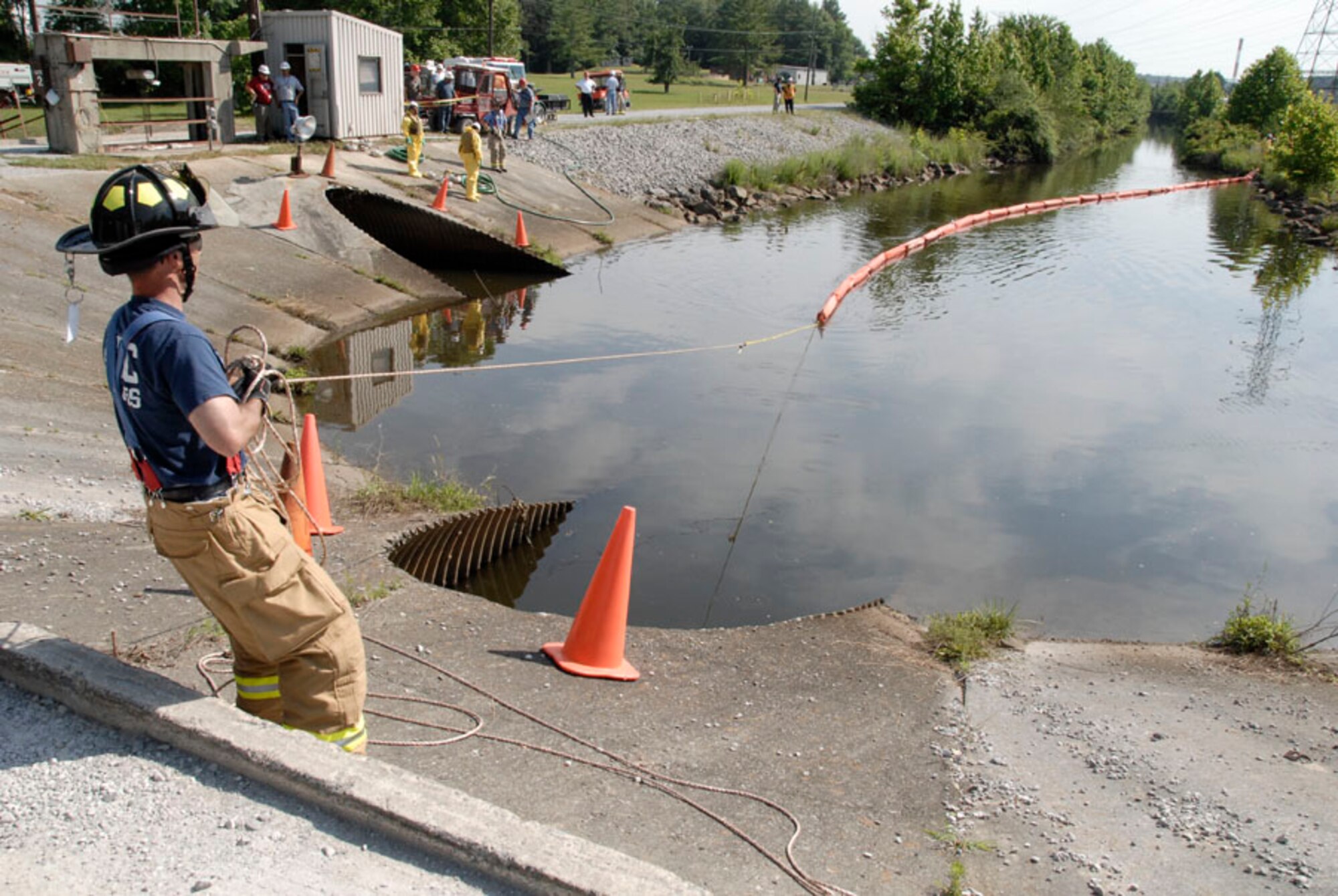 Aerospace Testing Alliance Firefighter Chuck King pulls a section of fuel buoys into position to contain a simulated fuel spill during an emergency response exercise on Arnold Air Force Base in June. (Photo by Rick Goodfriend)