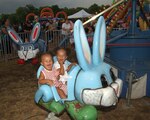 Jazmyn and Talayeh Reese, daughters of Staff Sgt. Jarvis Reese, 59th Medical Wing, enjoy their first-ever carnival ride July 4. The festival featured a carnival and "kidzone" tent filled with fun for children of all ages. (USAF photo by Alan Boedeker)

                     