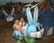Jazmyn and Talayeh Reese, daughters of Staff Sgt. Jarvis Reese, 59th Medical Wing, enjoy their first-ever carnival ride July 4. The festival featured a carnival and "kidzone" tent filled with fun for children of all ages. (USAF photo by Alan Boedeker)                     