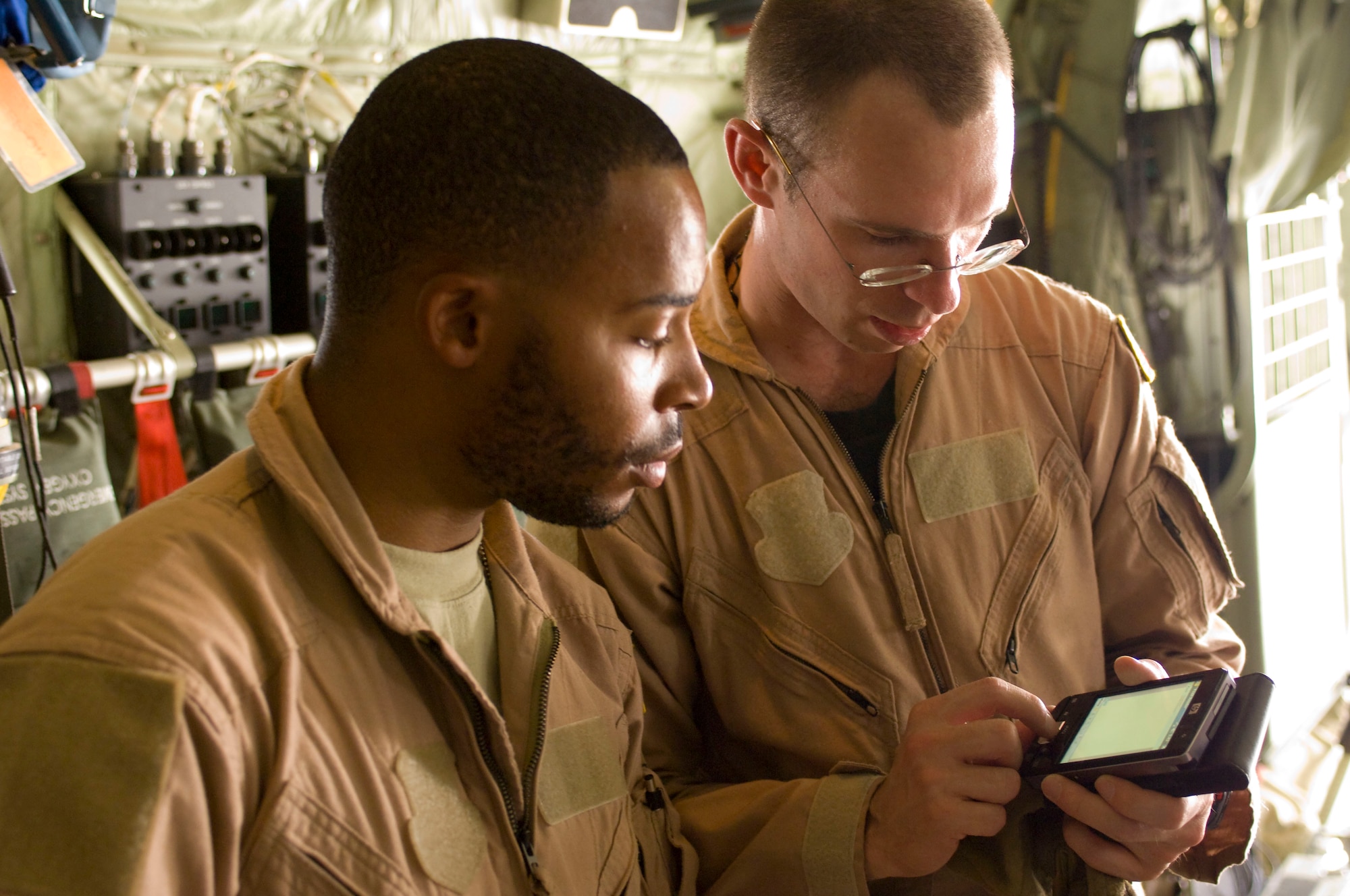 BAGRAM AIRFIELD, Afghanistan -- Staff Sgt. Elliot Dozier (left) and Capt. Matthew Rist (right) look up information on the Stryker Frame on a personal digital assistant inside a C-130 Hercules here on July 8, 2008. The Stryker Frame is a special stretcher designed to immobilize victims of spinal injuries. Sergeant Dozier and Captain Rist are deployed to the 455th Expeditionary Aeromedical Evacuation Flight from the 375th Aeromedical Evacuation Squadron, Scott Air Force Base, Ill. (U.S. Air Force photo by Staff Sgt. Samuel Morse)
