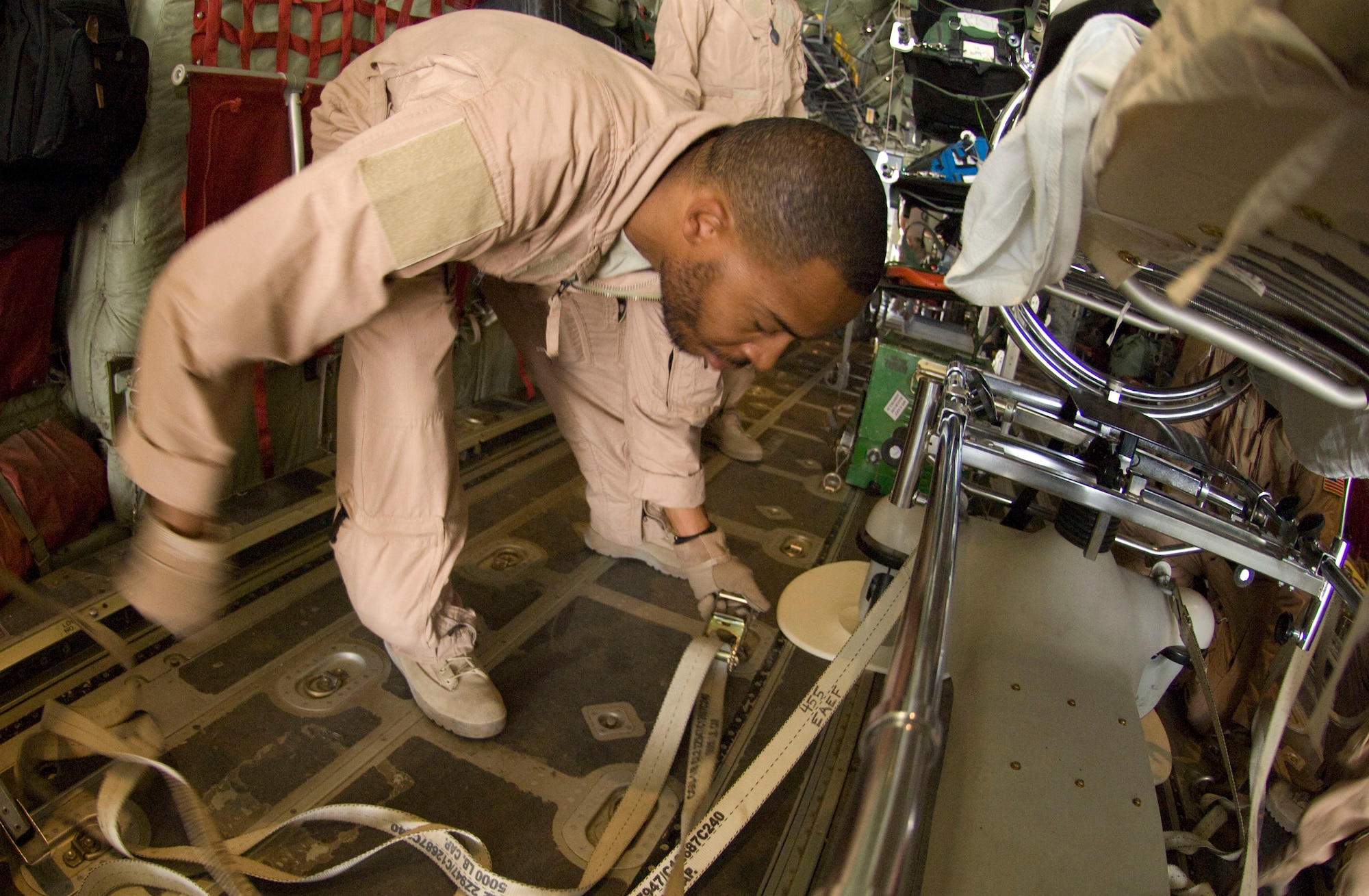 BAGRAM AIRFIELD, Afghanistan -- Staff Sgt. Elliot Dozier secures tie-downs to a Stryker Frame on a C-130 Hercules here July 8, 2008. The stretcher was the final piece of equipment converting this C-130 for aeromedical evacuation operations. Sergeant Elliot is deployed to the 455th Expeditionary Aeromedical Evacuation Flight here from the 375th Aeromedical Evacuation Squadron, Scott Air Force Base, Ill. (U.S. Air Force photo by Staff Sgt. Samuel Morse)