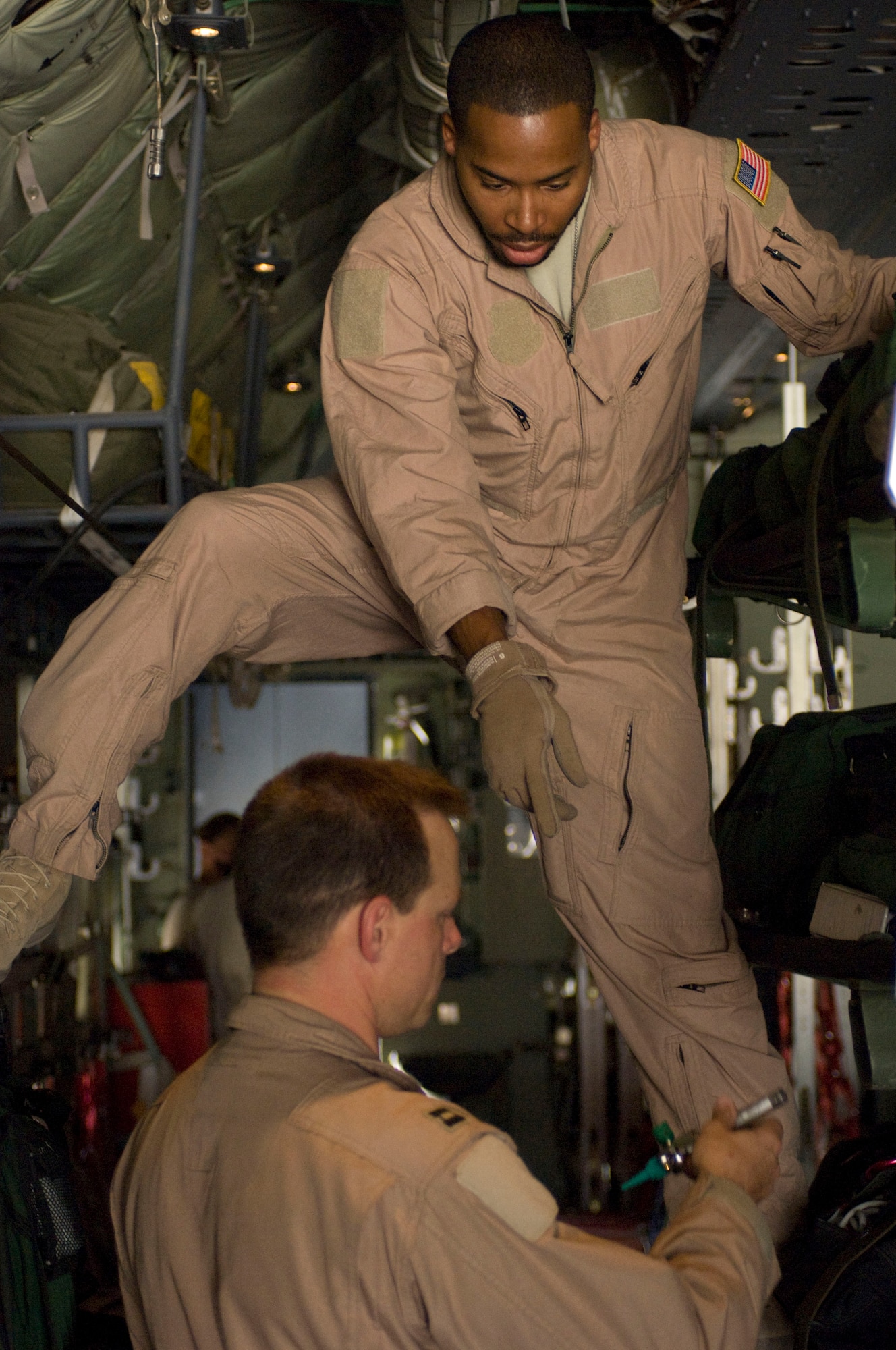 BAGRAM AIRFIELD, Afghanistan -- Capt. Arthur Anderson hands medical supplies to Staff Sgt. Elliot Dozier in a C-130 Hercules here on July 8, 2008. Captain Anderson and Sergeant Dozier were part of the team from the 455th Expeditionary Aeromedical Evacuation Flight that converted this C-130 for an aeromedical evacuation mission. The two are deployed to Bagram Air Field from the 375th Aeromedical Evacuation Squadron, Scott Air Force Base, Ill. (U.S. Air Force photo by Staff Sgt. Samuel Morse)