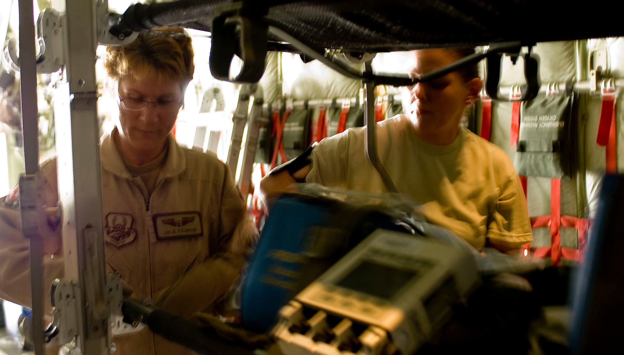 BAGRAM AIRFIELD, Afghanistan -- Maj. Julie Faubion (left) and Tech. Sgt. Alexandria Young (right) position a litter in a C-130 Hercules here on July 8, 2008. Major Faubion and Sergeant Young helped convert this C-130 for aeromedical evacuation. The entire aerovac team is deployed from the 375th Aeromedical Evacuation Squadron, Scott Air Force Base, Ill. (U.S. Air Force photo by Staff Sgt. Samuel Morse)