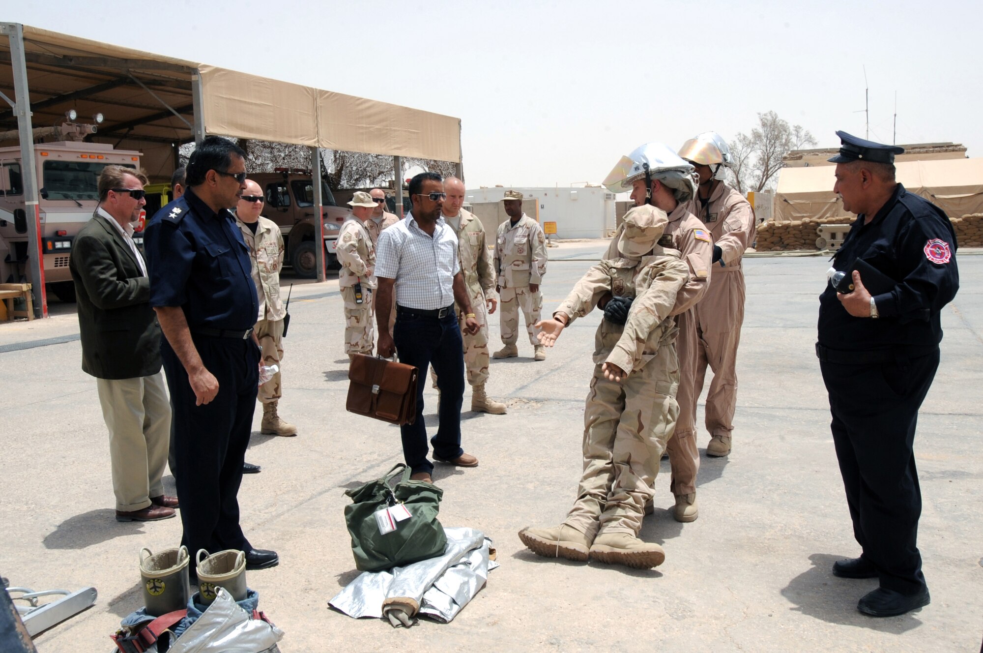 ALI BASE, Iraq -- Senior Airmen Robert Hanks and Jason Lewis demonstrate rescue procedures during a firefighting training demonstration for local Iraqi officials, the Muthanna Provincial Director of Emergency Services and Al Khidr Fire Chief. The demonstration's goal was to showcase the training Iraqi firefighters will receive when they attend the Basic Firefighter Course here. Both Airmen are firefighters assigned to the 407th Expeditionary Civil Engineer Squadron and deployed from Travis Air Force Base, Calif. (U.S. Air Force photo/Tech. Sgt. Sabrina Johnson)