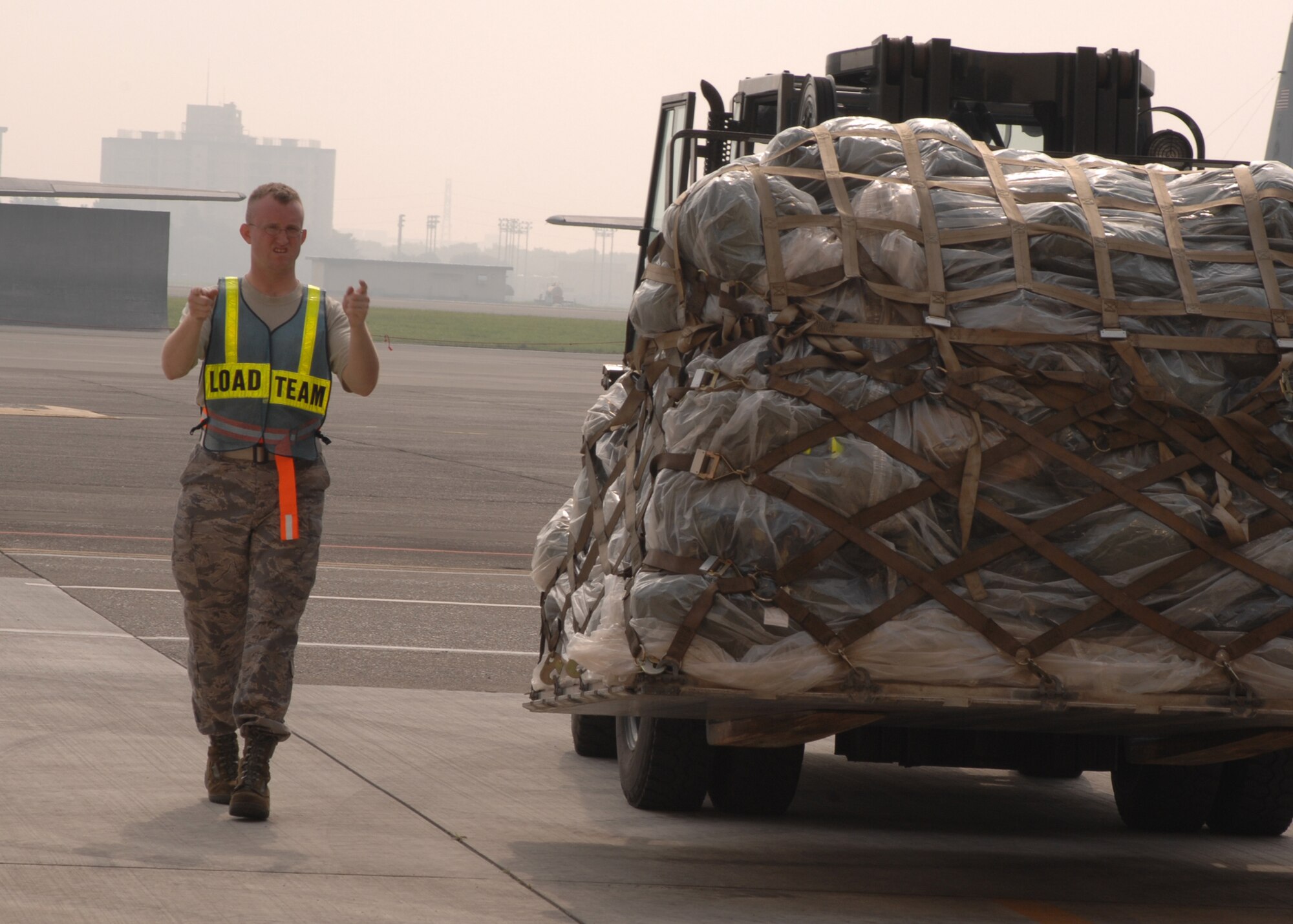 YOKOTA AIR BASE, Japan - Senior Airman Jason Graham, from the 374th Maintenance Squadron, guides a 10K Standard Loader carrying a pallet during Exercise Beverly Morning 08-07 on July 11. The exercise is designed to test the base's deployment and operational readiness. (U.S. Air Force photo by Airman 1st Class Jonathan Fowler)