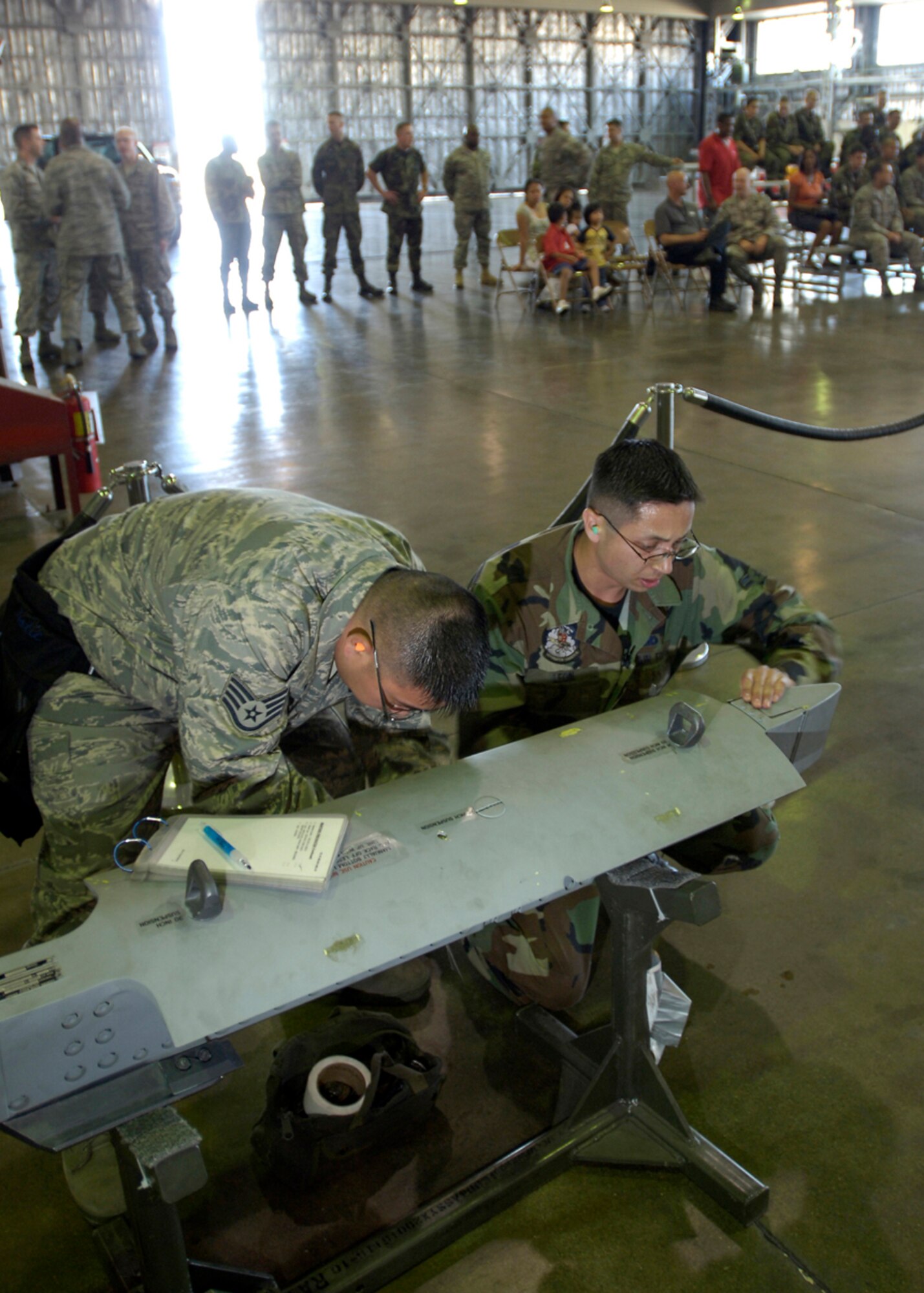 MISAWA AIR BASE, Japan -- Staff Sgt. Sherwyn Mabute and Airman 1st Class Noe Leon, 35th AMXS, double check their work before finishing during the 2nd quarter load crew competition July 2, 2008. The winning team will be announced at a later date. ( U.S. Air Force photo by Senior Airman Chad Strohmeyer)